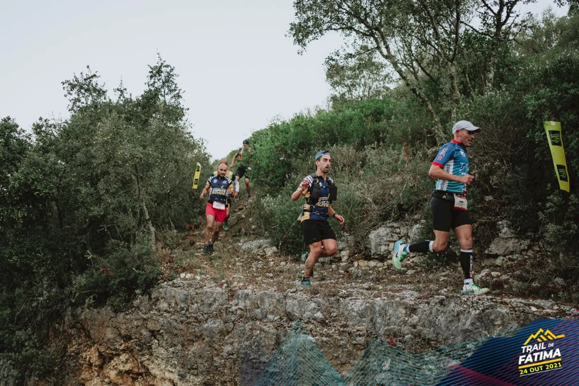 The image depicts a group of trail runners participating in an outdoor event, presumably a