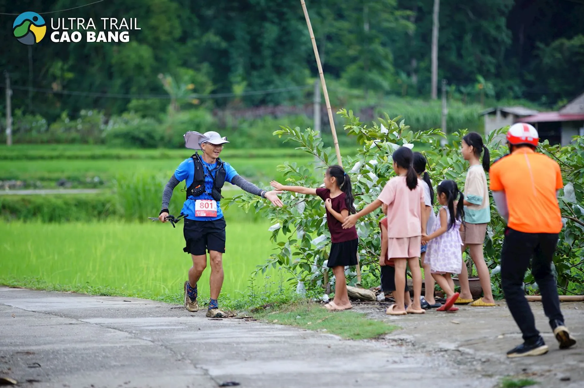 In this image, there's a male runner wearing a blue shirt, black shorts