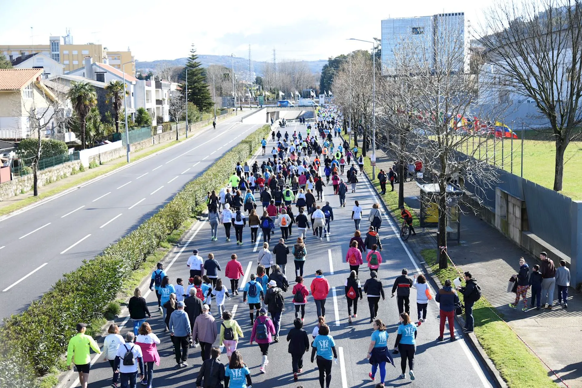 The image shows a group of people participating in a running event. They are running