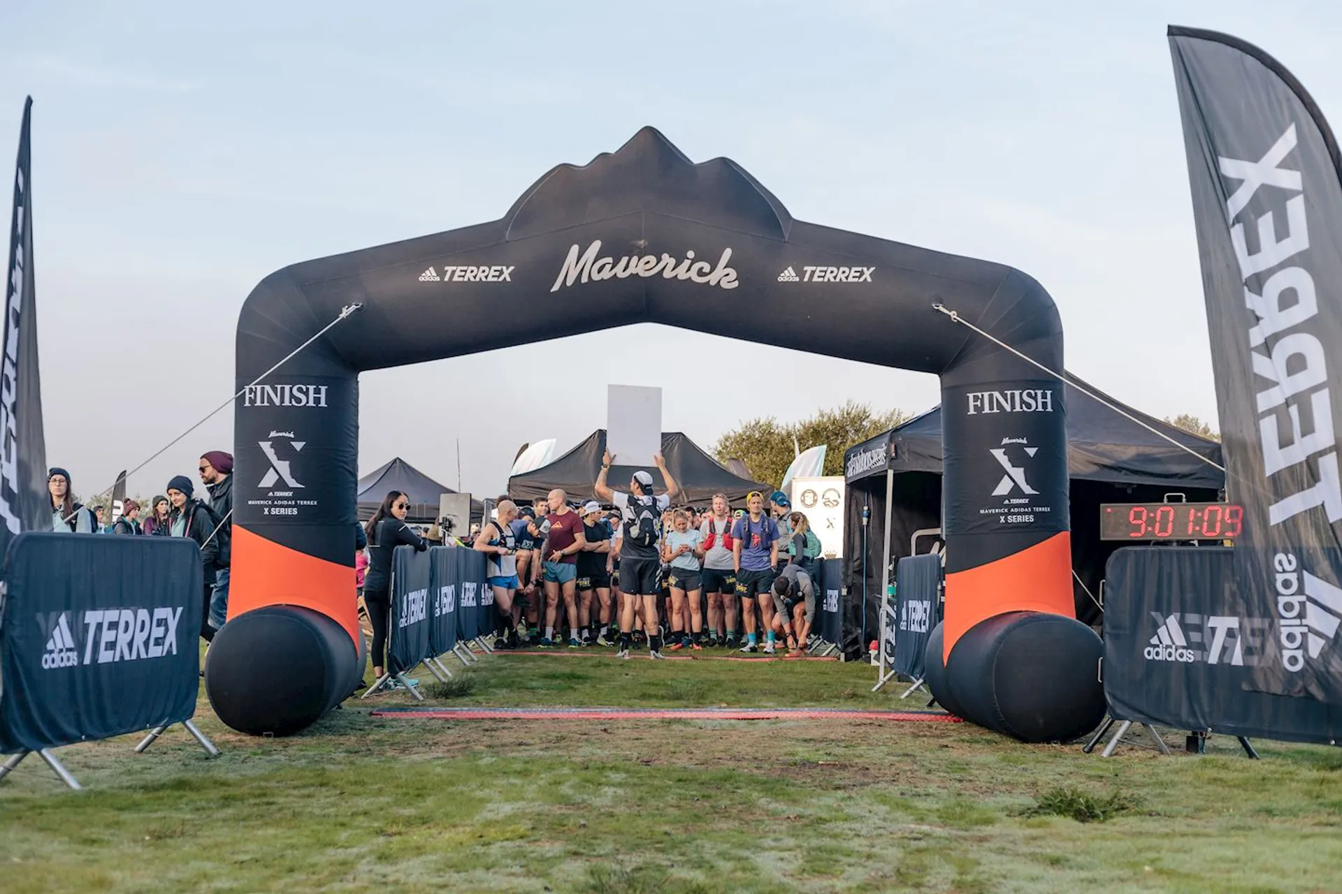 The image shows a group of runners just about to cross the finish line at an