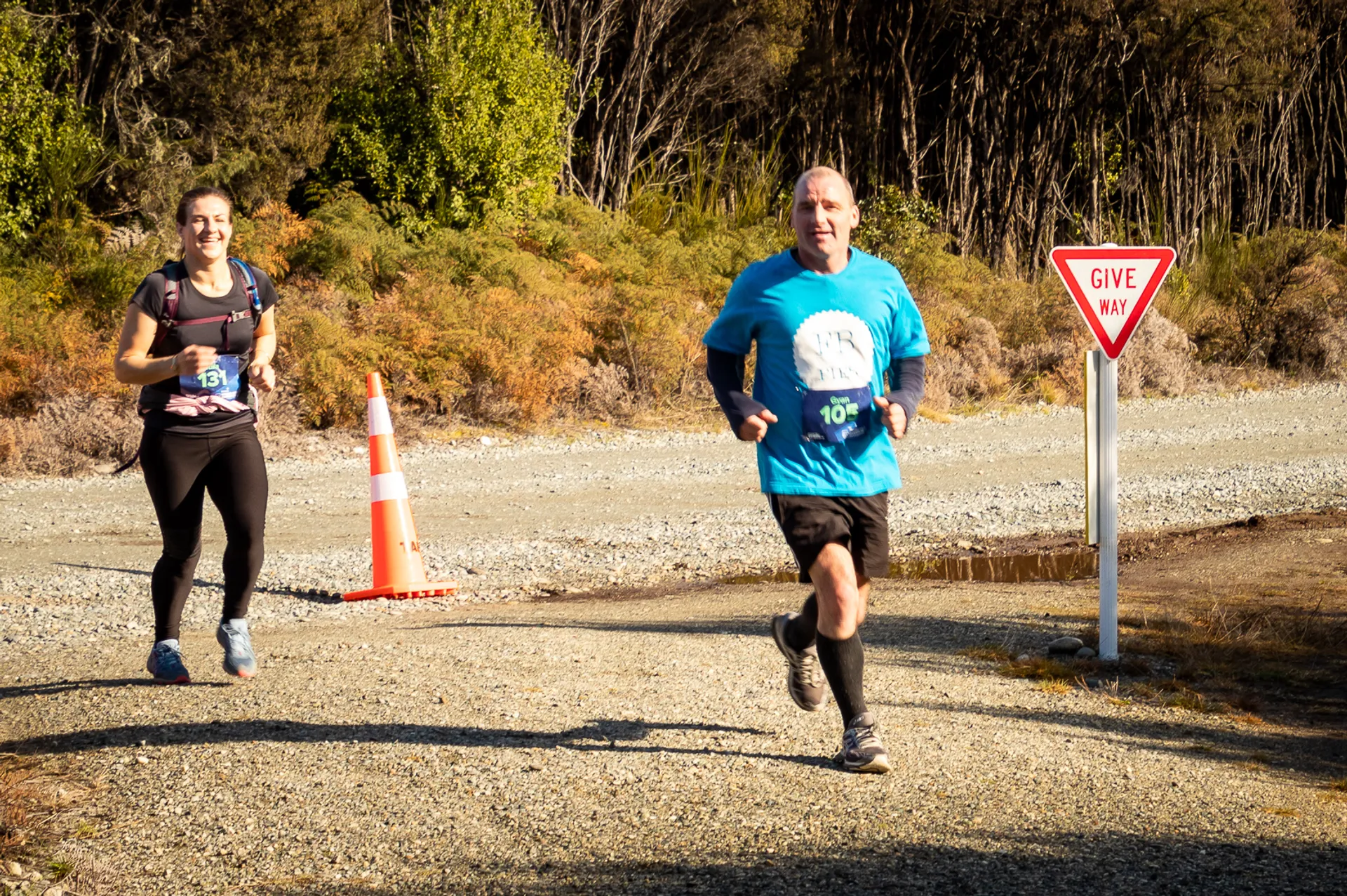 The image shows two runners participating in a race or a running event. The environment
