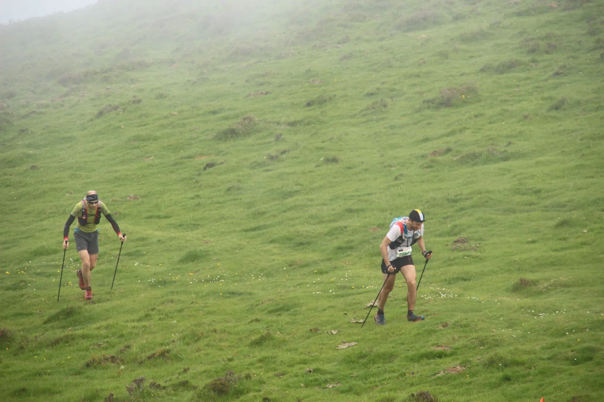 The image shows two individuals engaged in an outdoor activity, likely hiking or Nordic walking