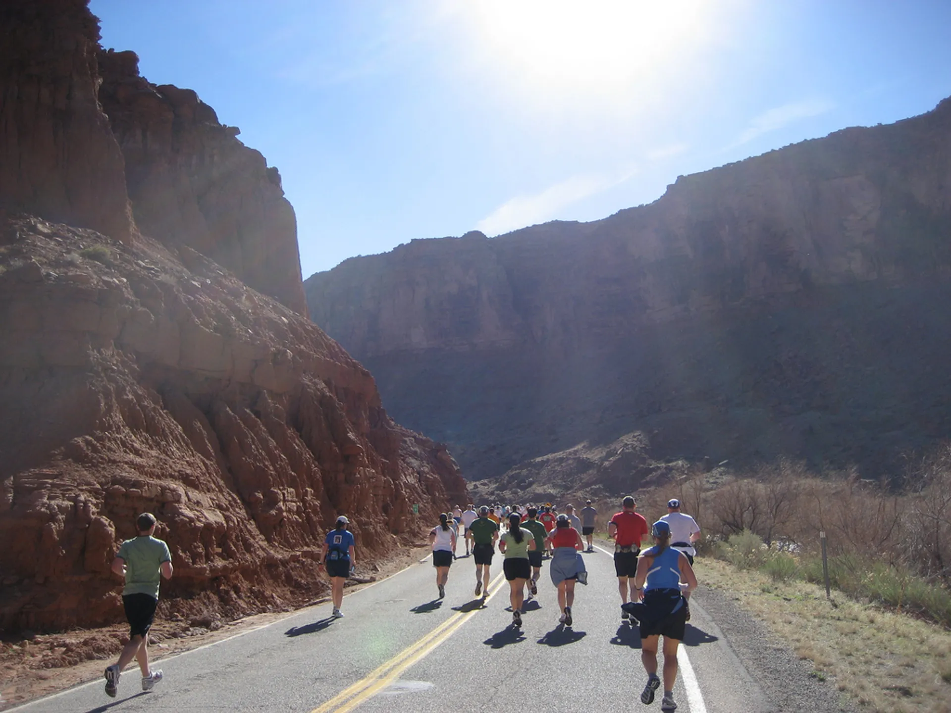 The image shows a group of runners participating in a road race. They are surrounded