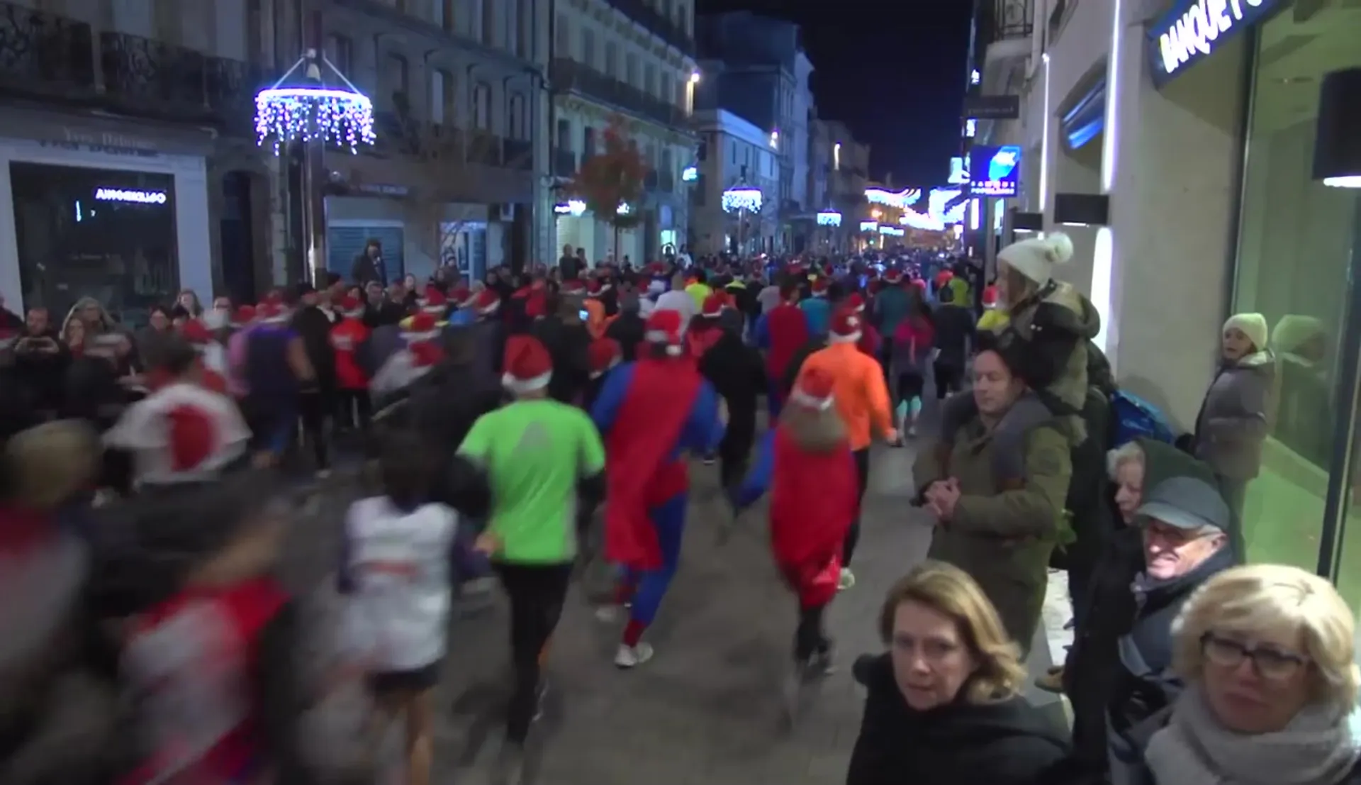 This image shows a bustling street scene at night, where a group of people are