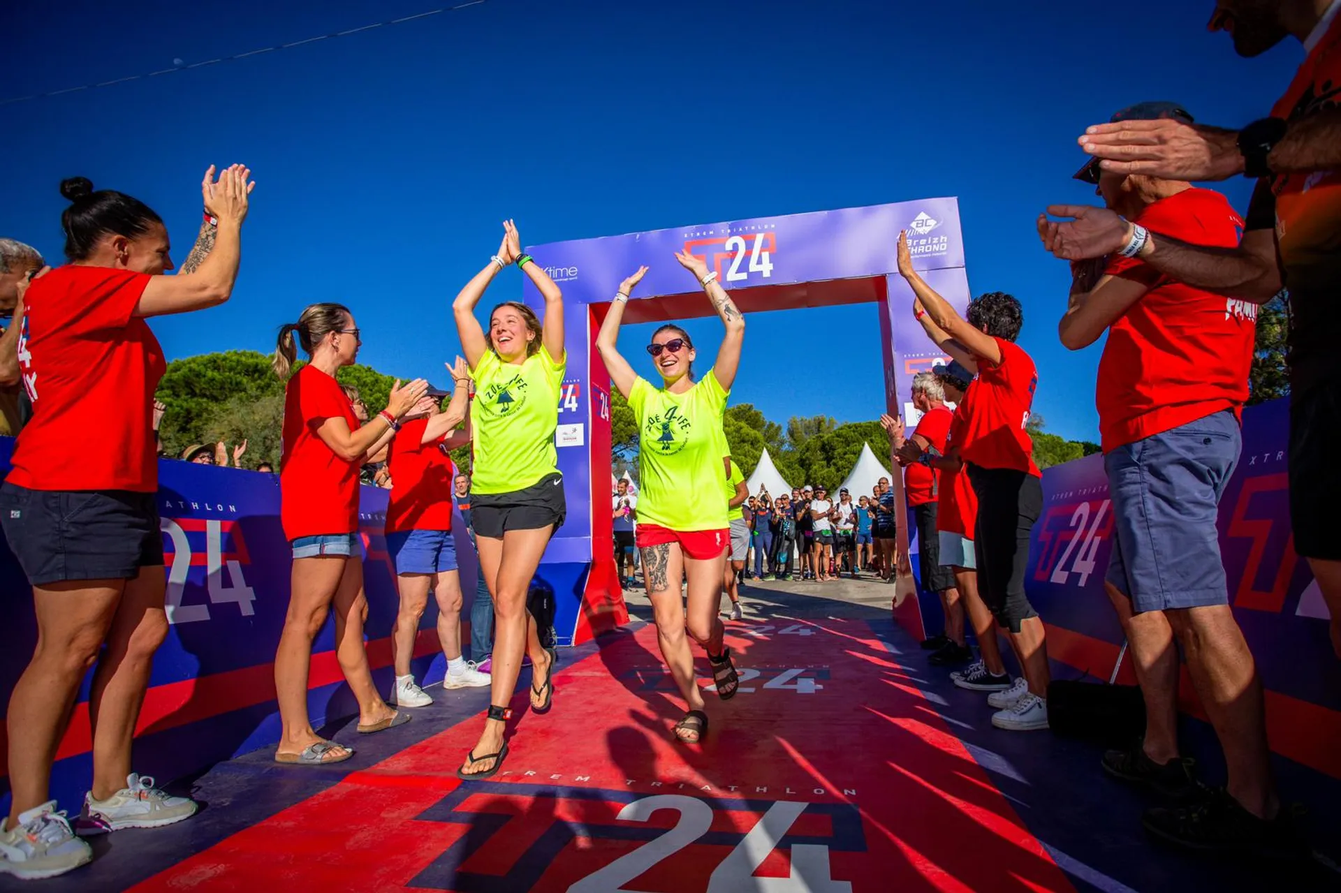 The image shows a jubilant scene at what appears to be the finish line