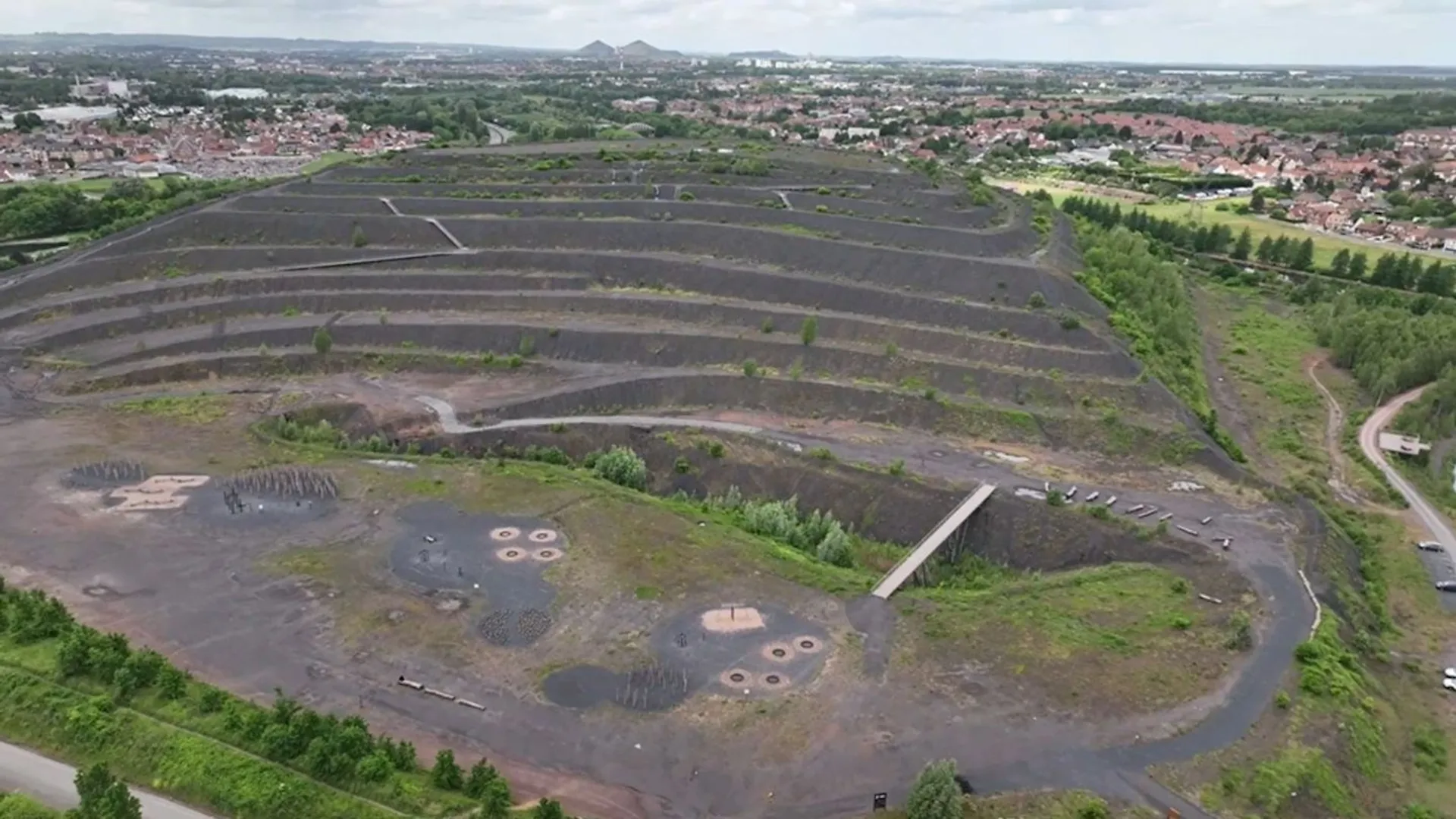 The image shows an aerial view of a large, terraced landscape with a distinctive