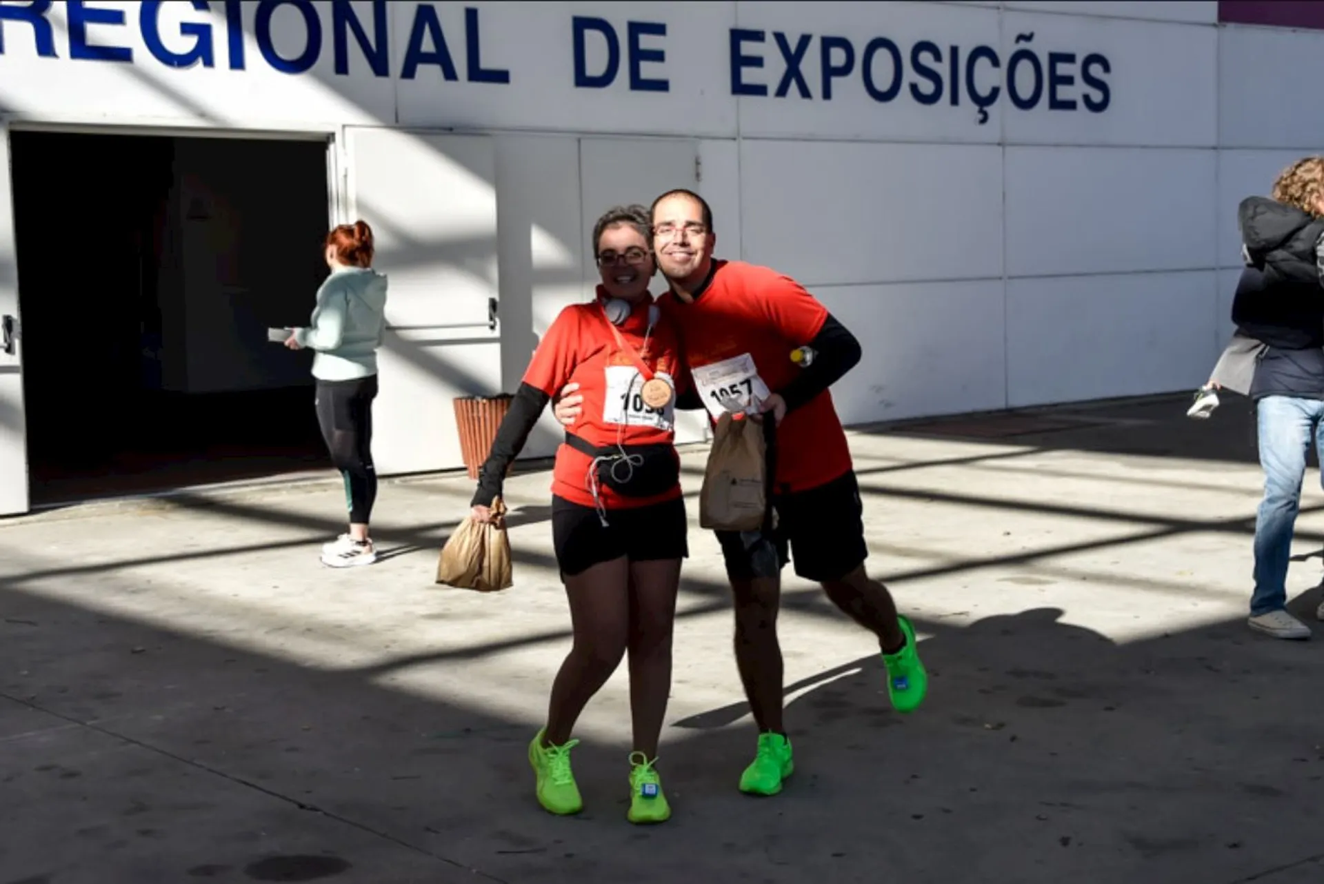The image shows two individuals posing for a photo at what appears to be a running
