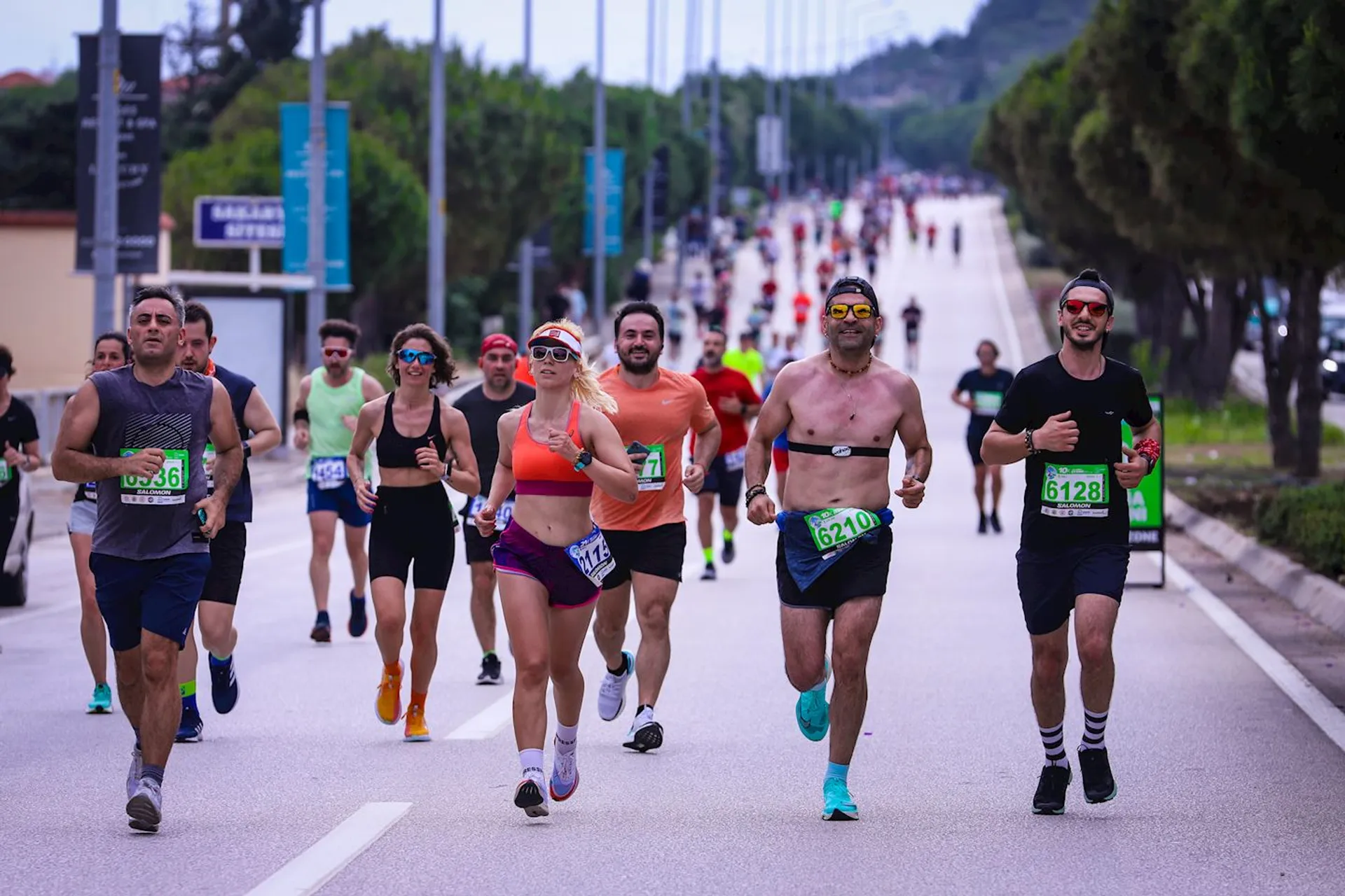 The image depicts a group of people participating in a running event or marathon. They