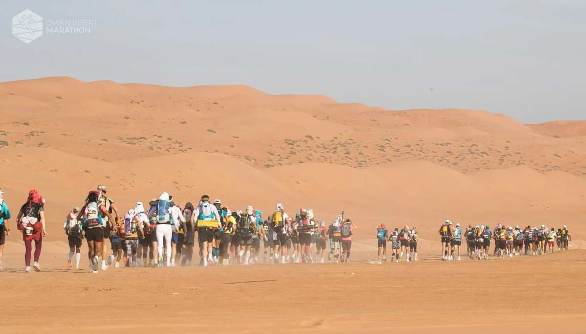 The image shows a group of individuals participating in a marathon or long-distance race in
