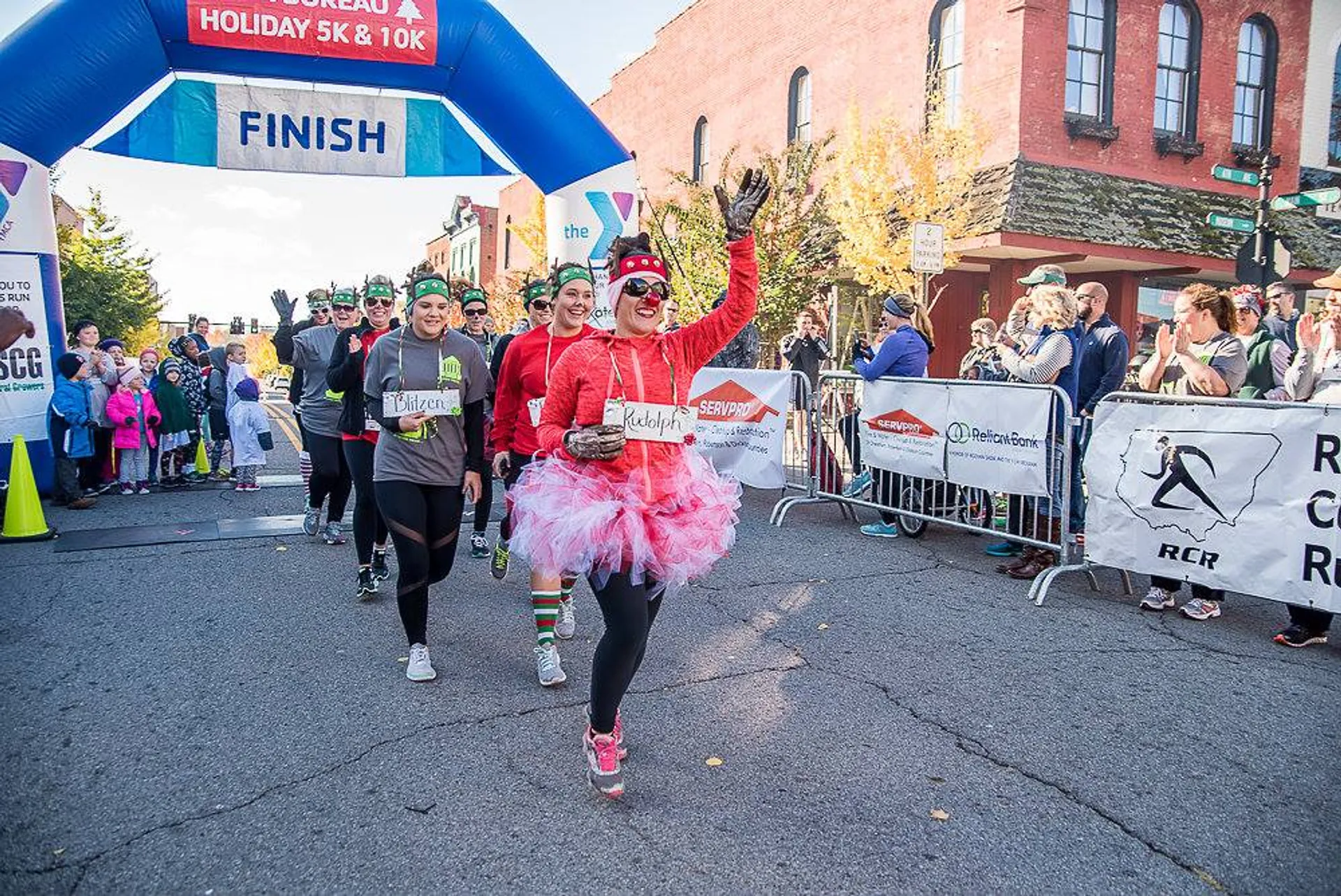 In the image, we see a group of runners crossing the finish line at a