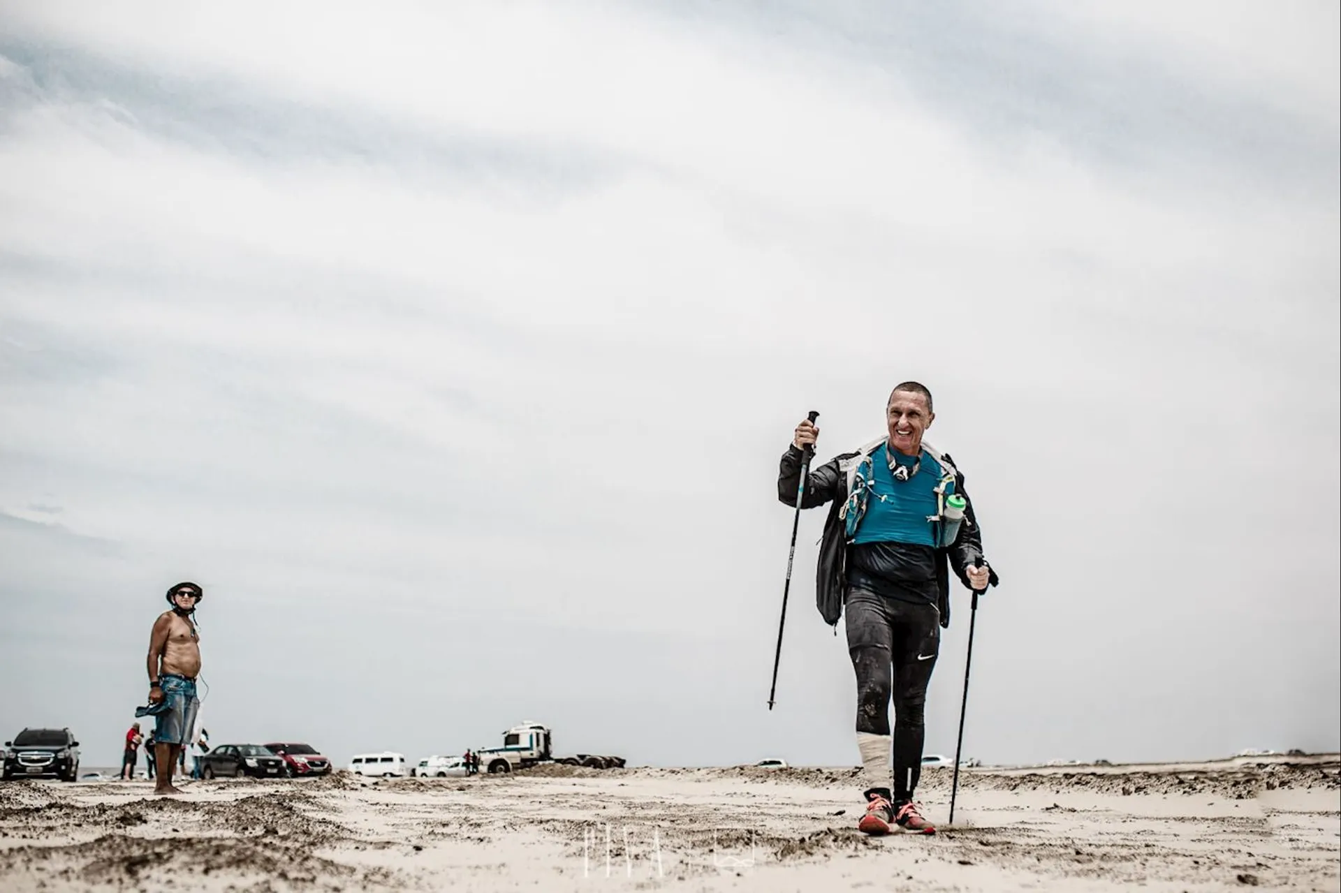 In this image, there are two people on what appears to be a sandy area