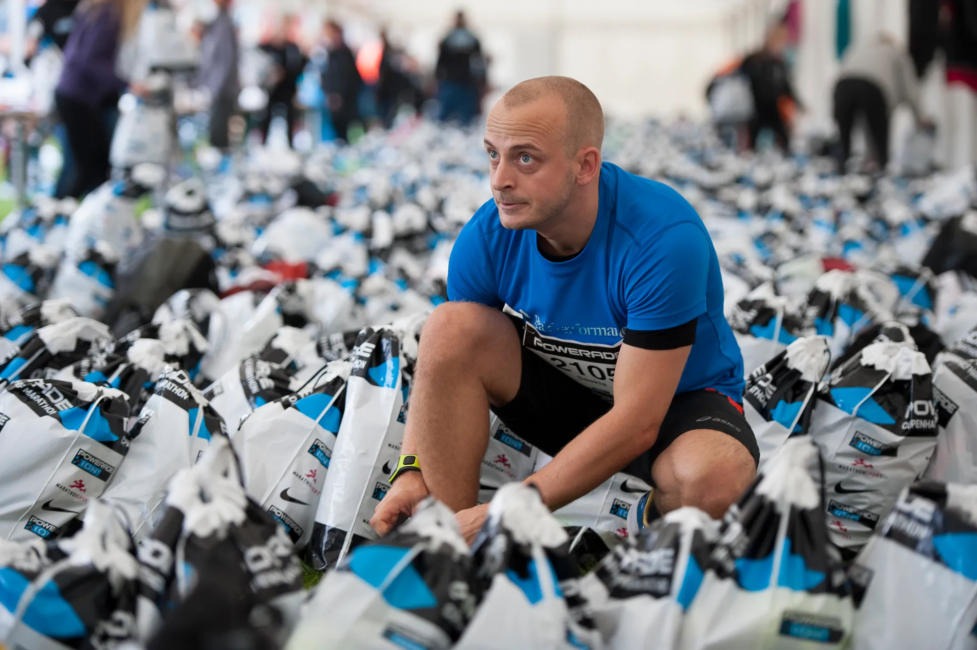 In the image, there is a man crouched on the ground among a