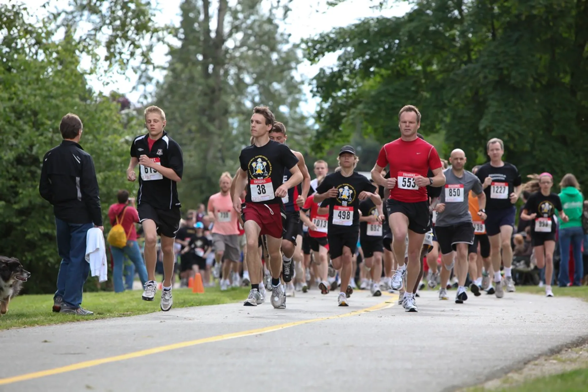 This image shows a group of people participating in a road running event. The runners