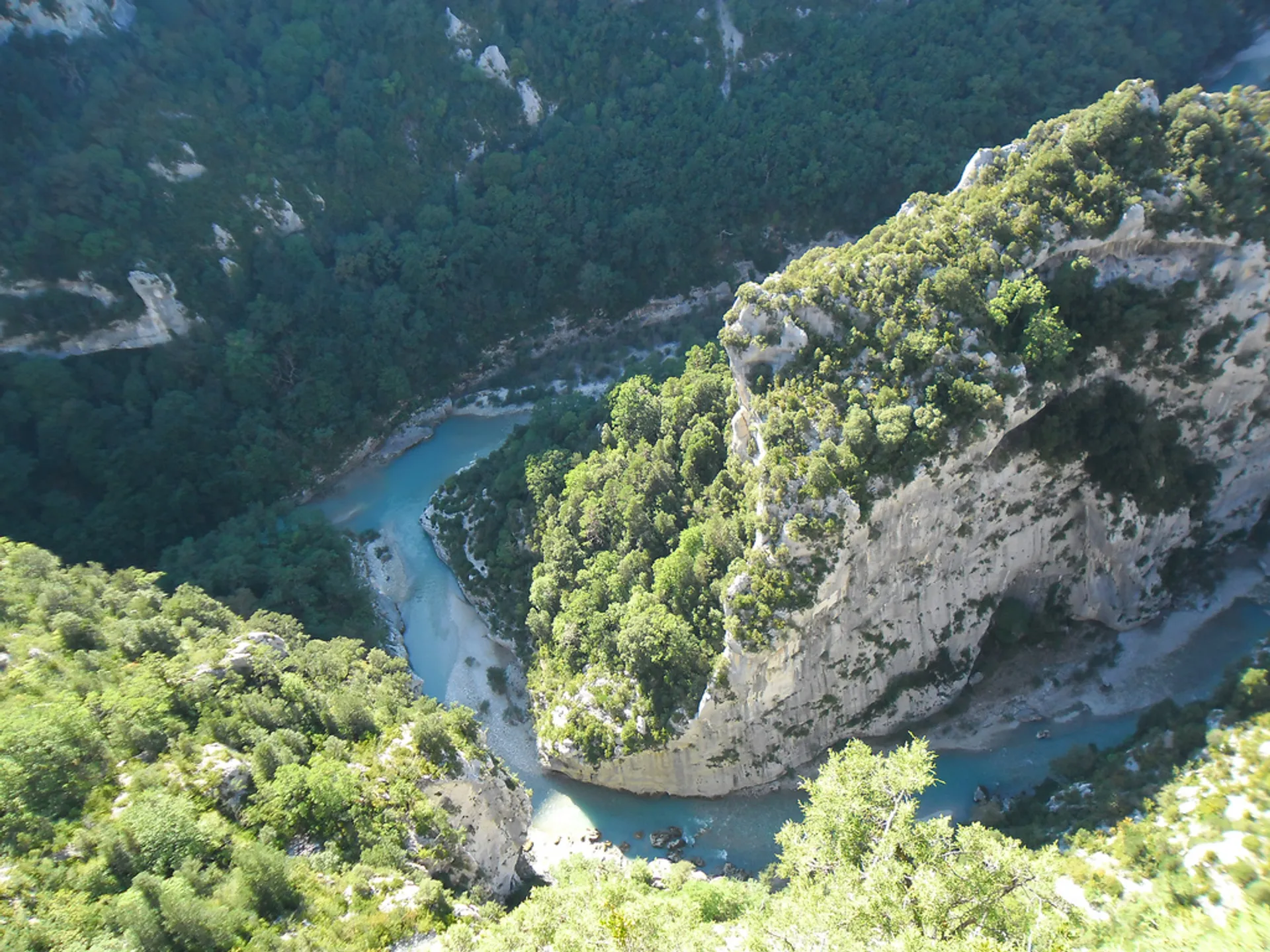 This image depicts a meandering river cutting through a deep gorge or canyon. The