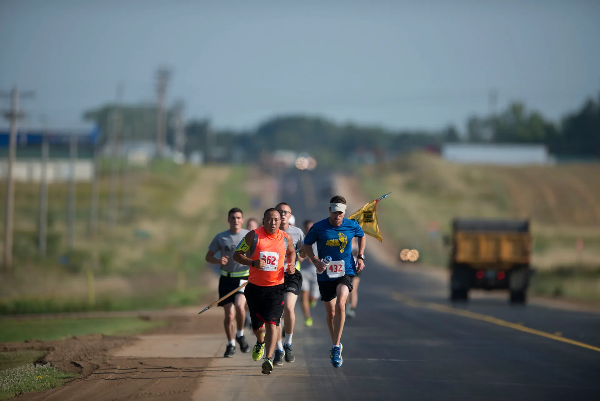 The image shows a group of runners participating in a race or running event. They