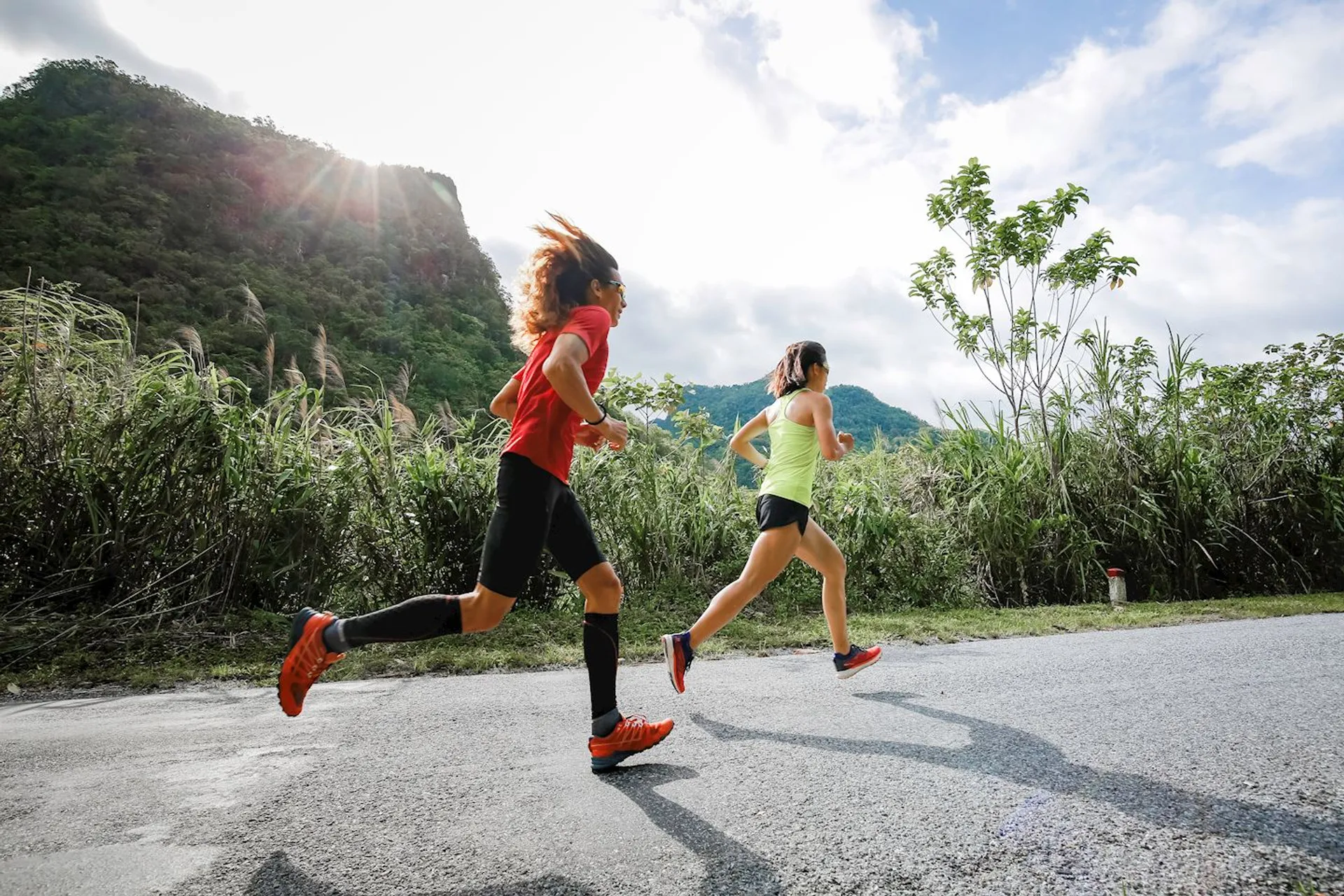 In this image, there are two individuals engaged in outdoor running. The person in