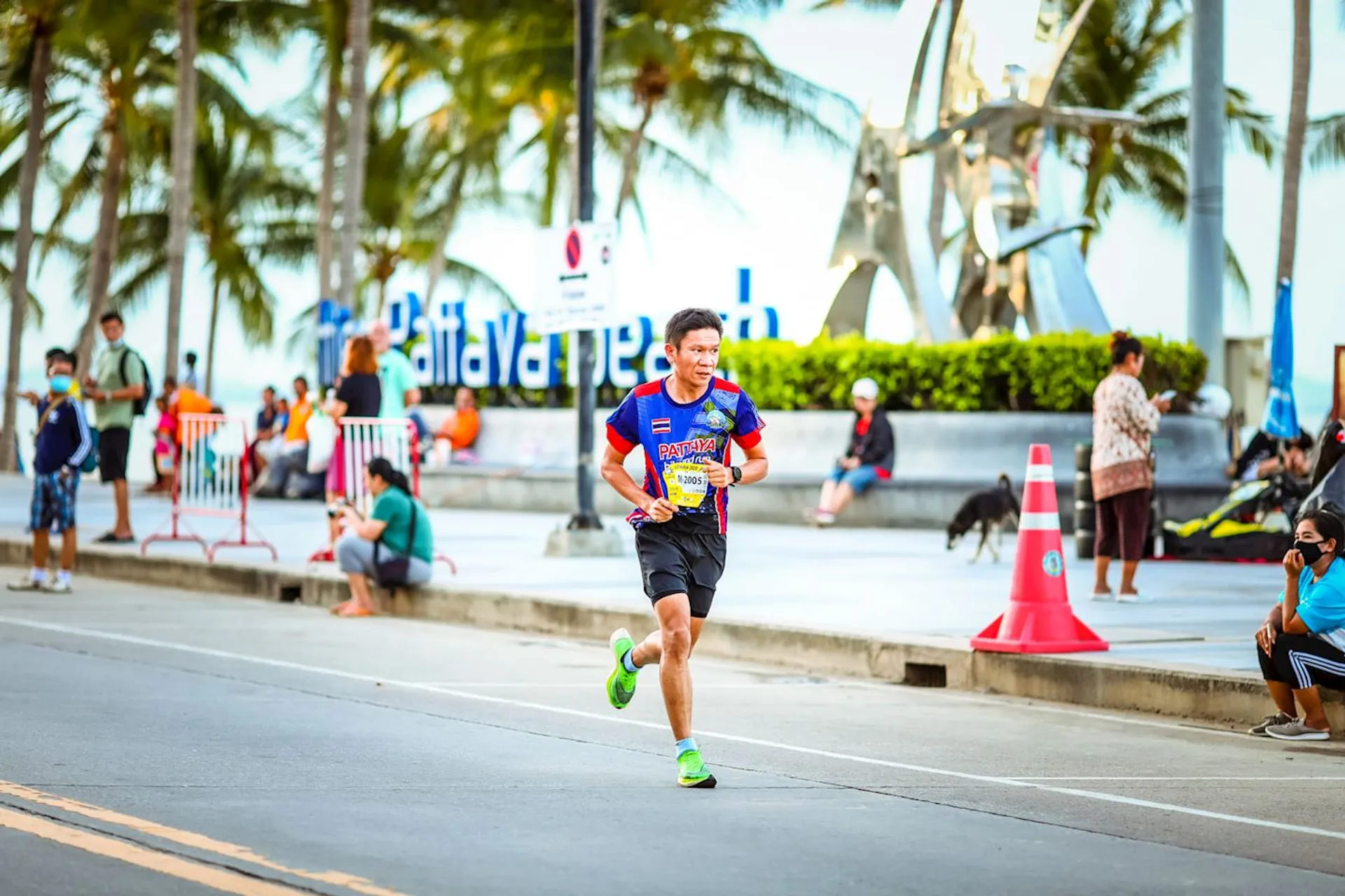The image shows a man participating in a road running event. He is dressed in