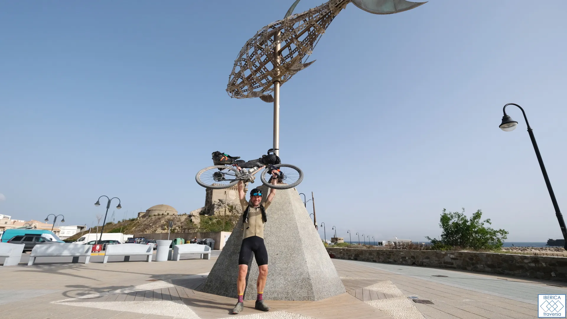 The image shows a person holding up a bicycle over their head with a large,