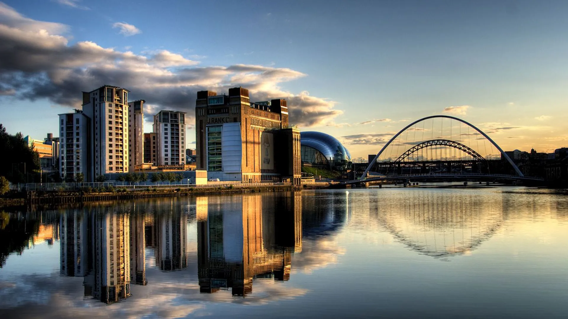 The image shows a modern cityscape during what appears to be either sunrise or sunset