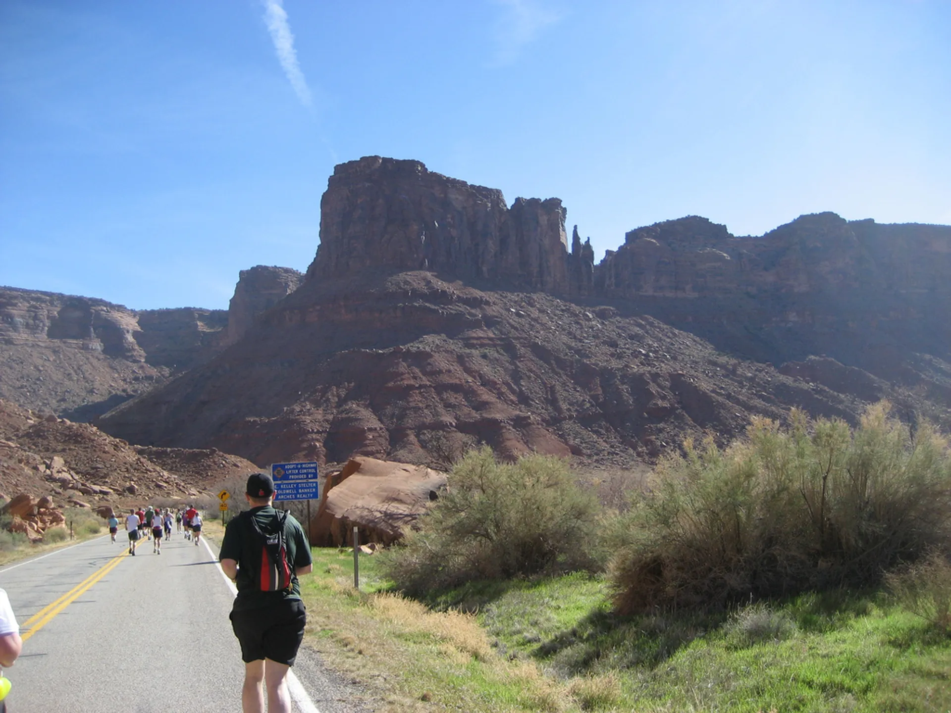 The image depicts a group of runners participating in an event, likely a marathon or