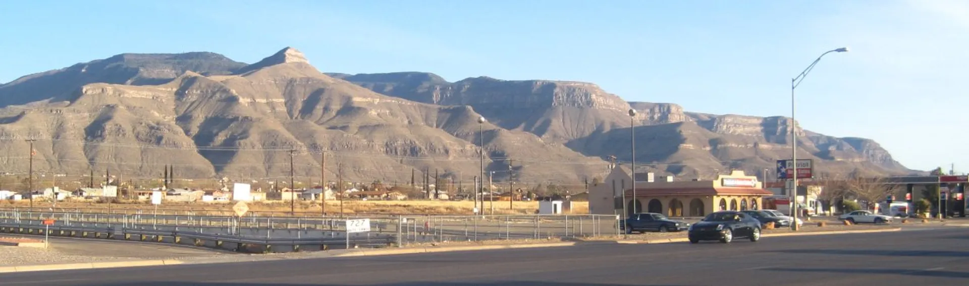 The image shows a street view with a few vehicles on the road. In the