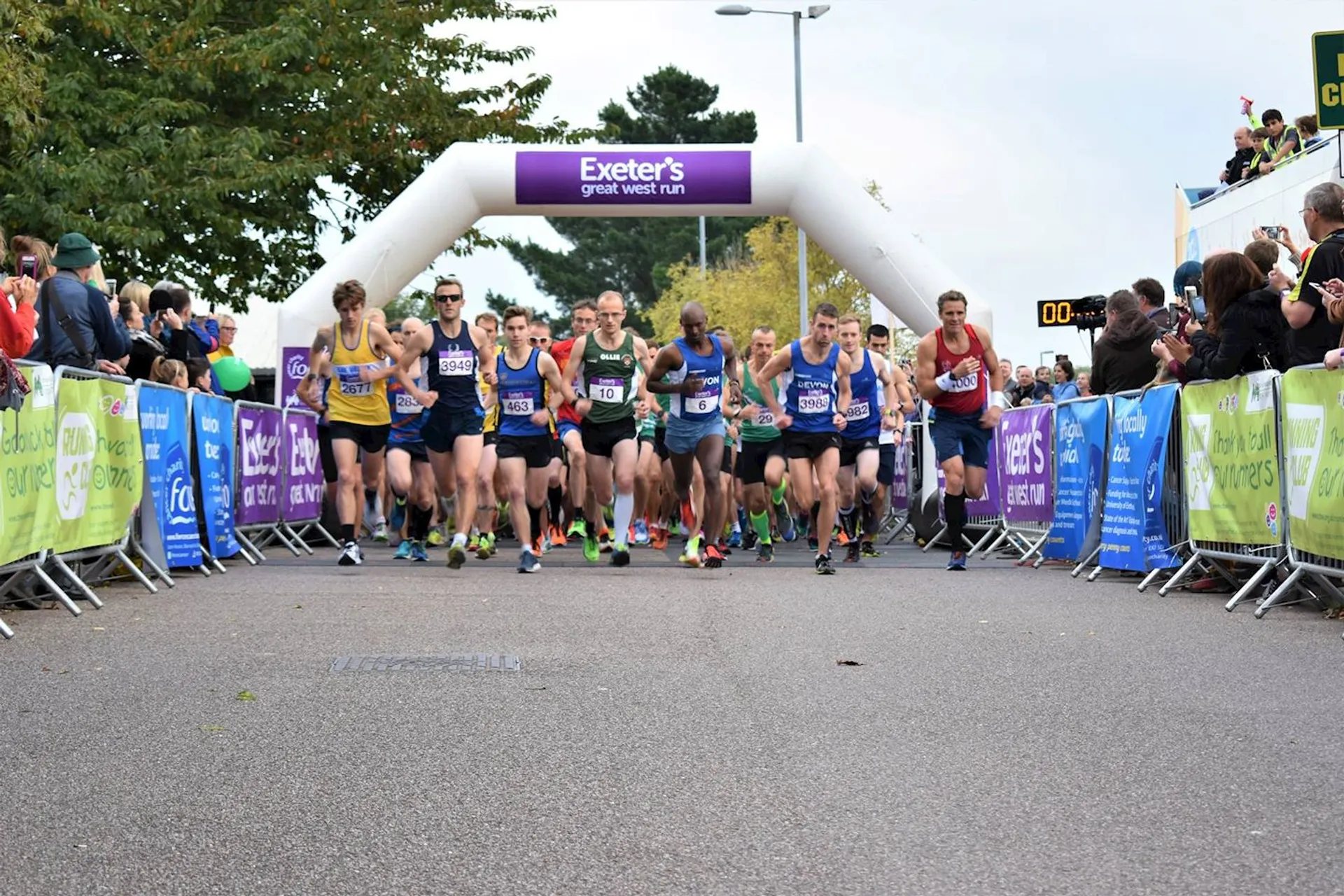 The image depicts a group of runners at the starting line of a race. They