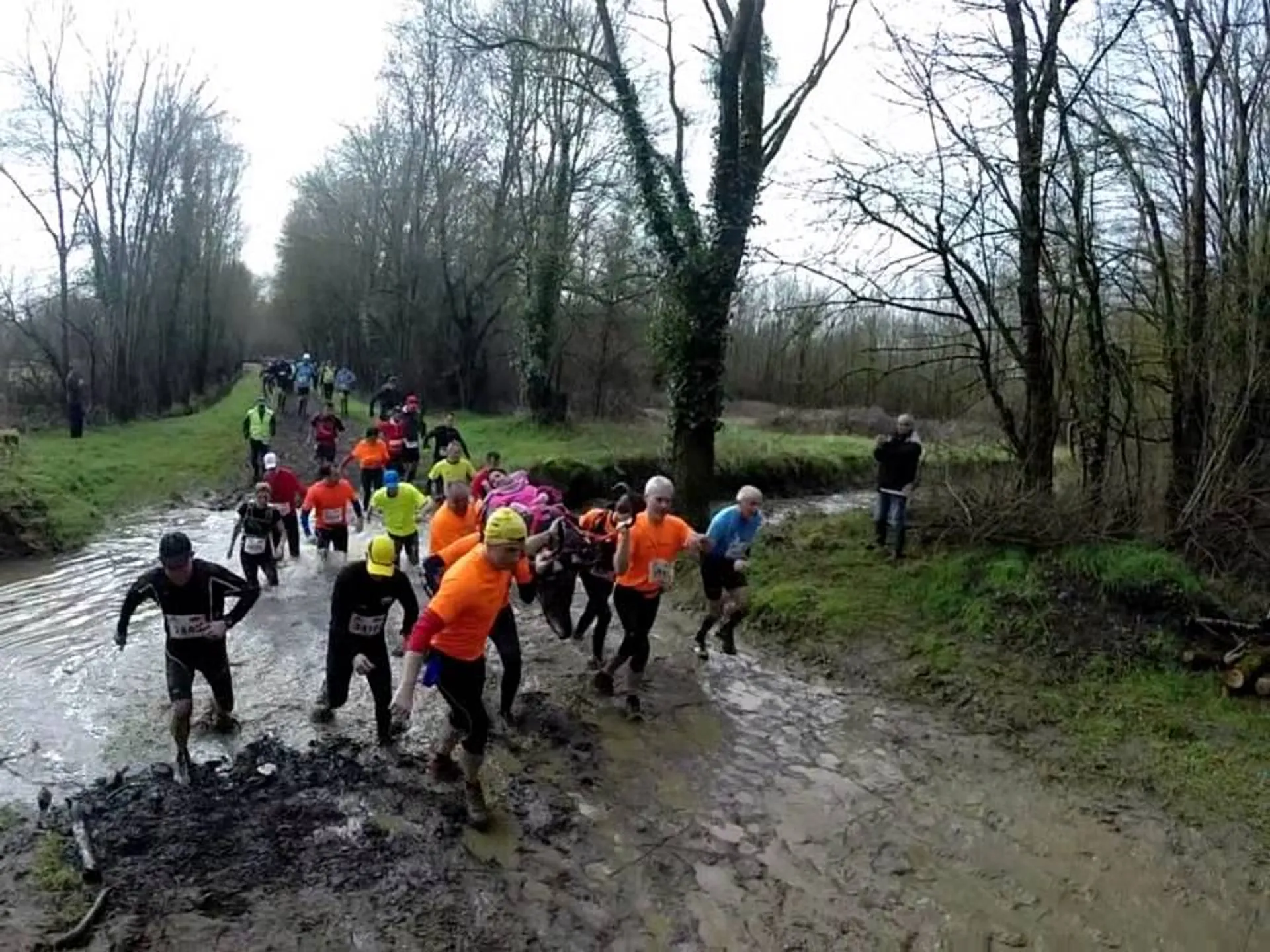 The image shows a group of people participating in what appears to be a mud run