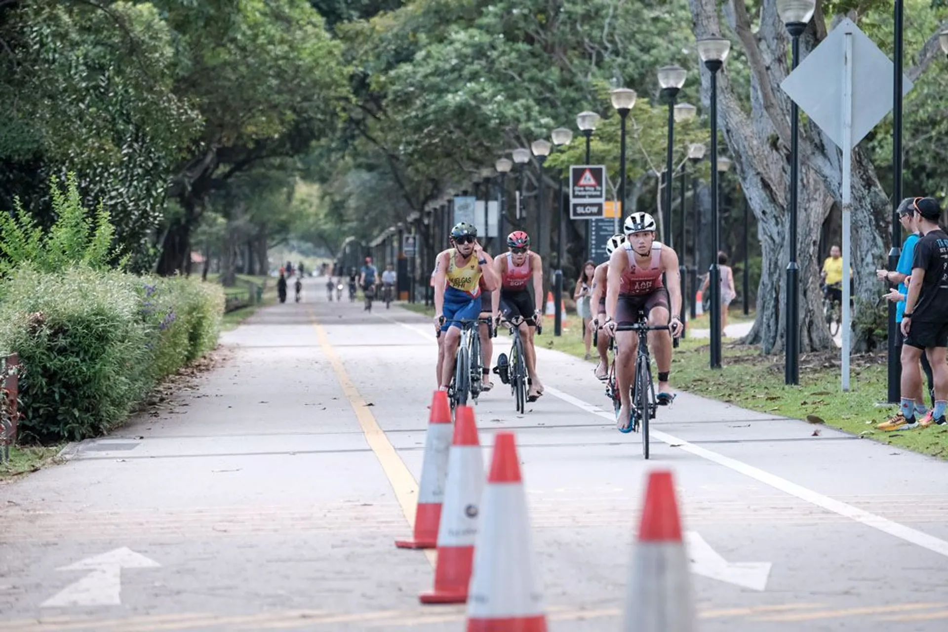 The image shows a group of cyclists on a road, evidently part of a bicycle