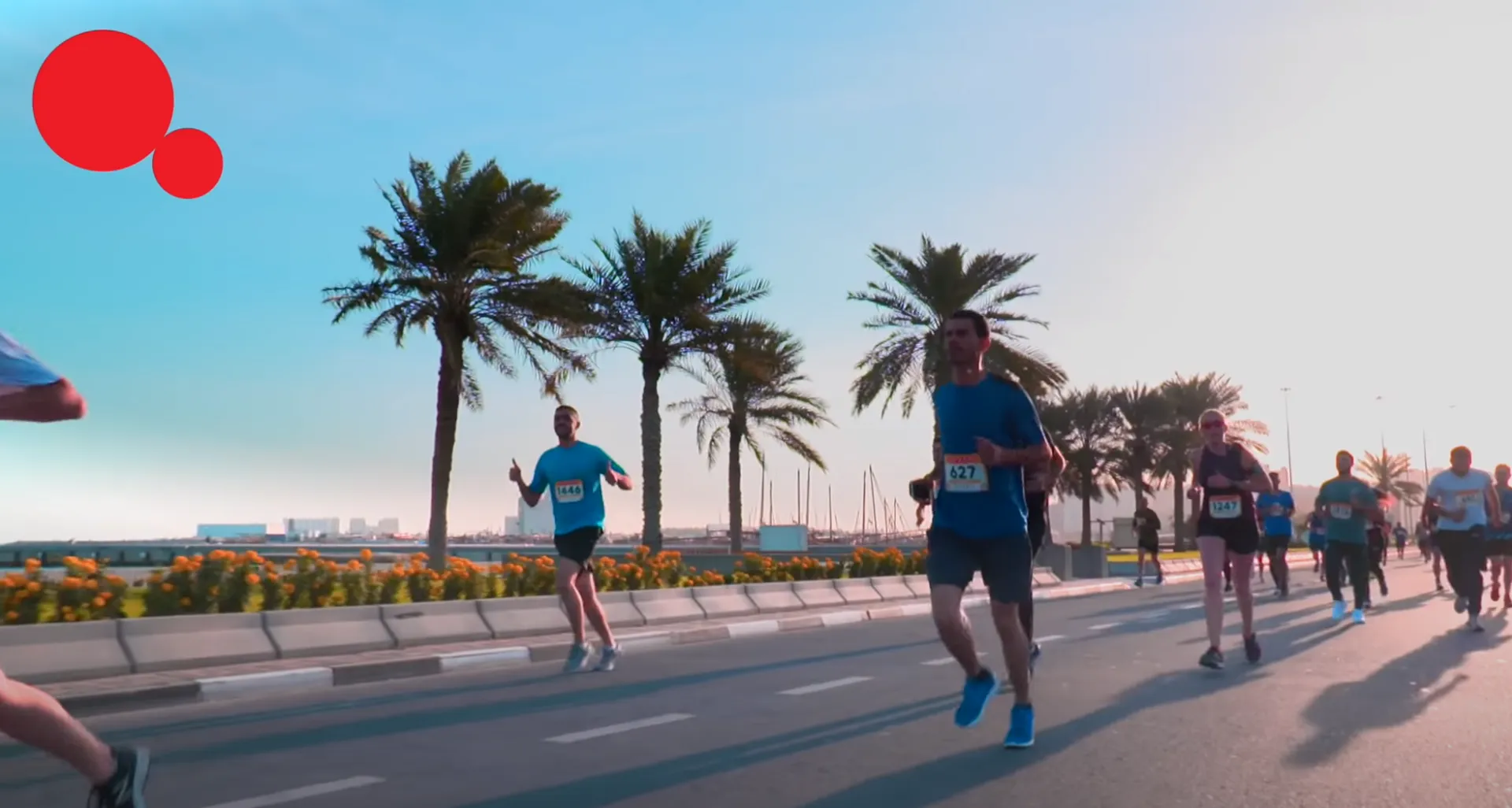 This is an image of a road race event, with several participants running. There