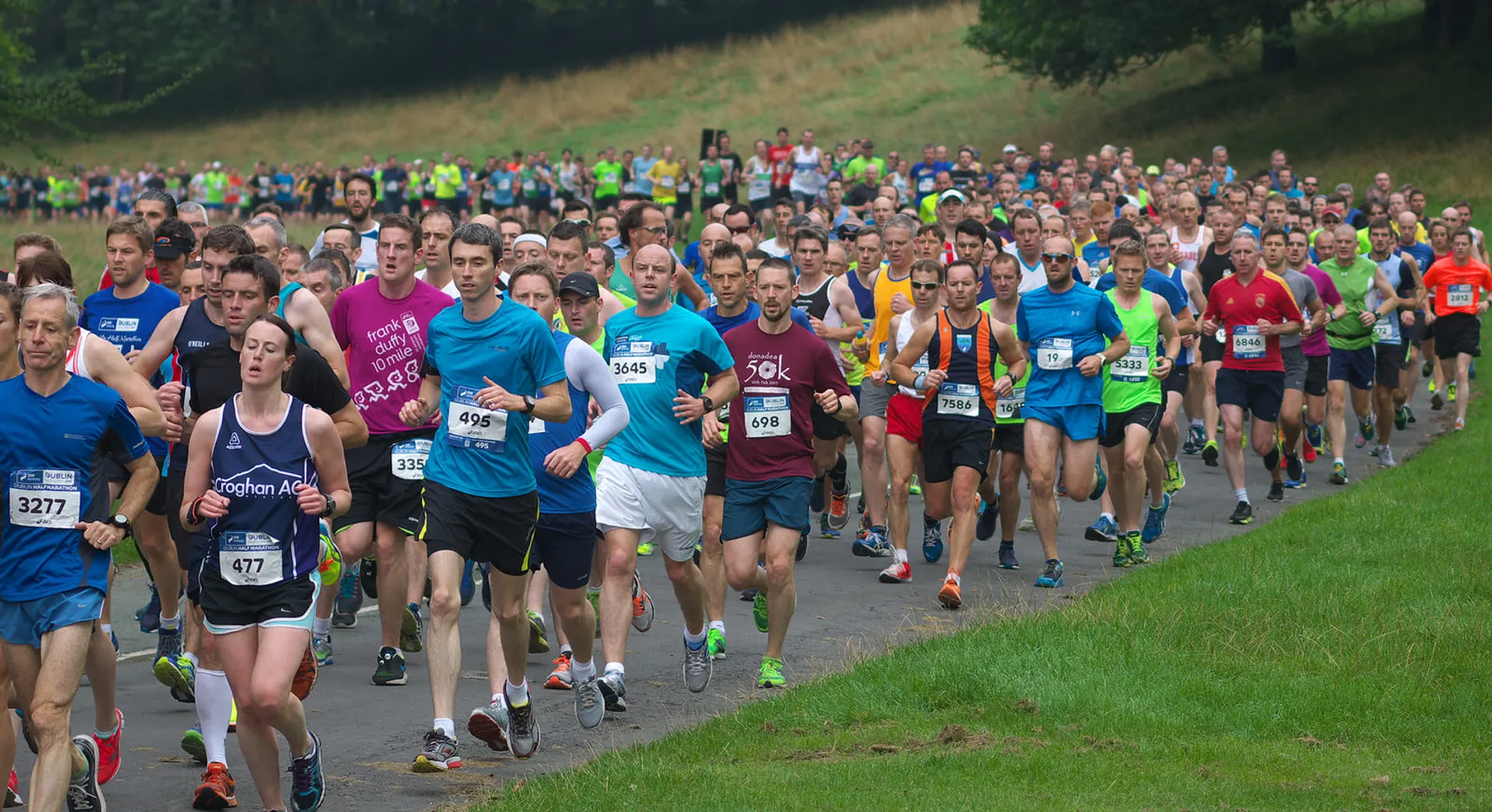 The image shows a large group of people participating in a running event, possibly a