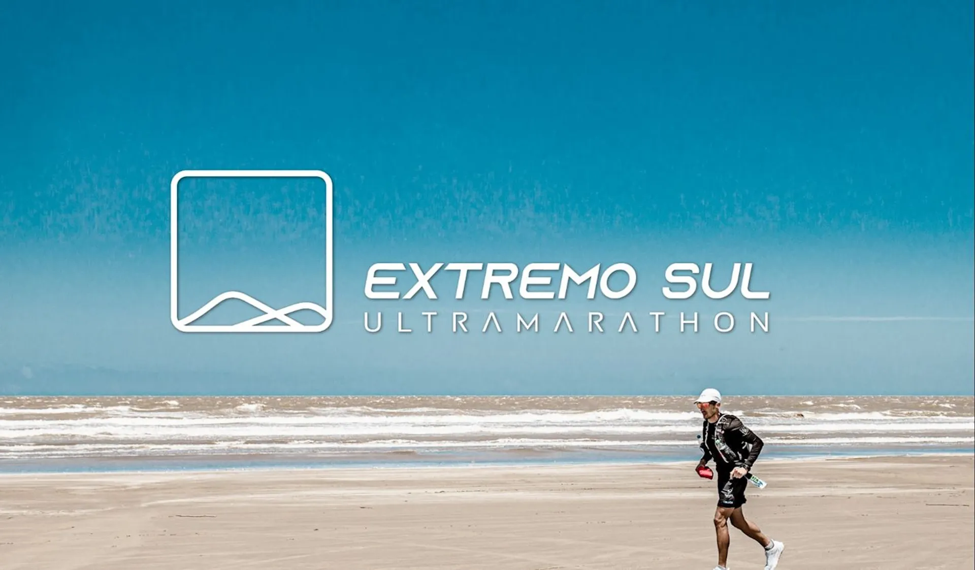 The image shows a person running on a beach. They are dressed in athletic gear