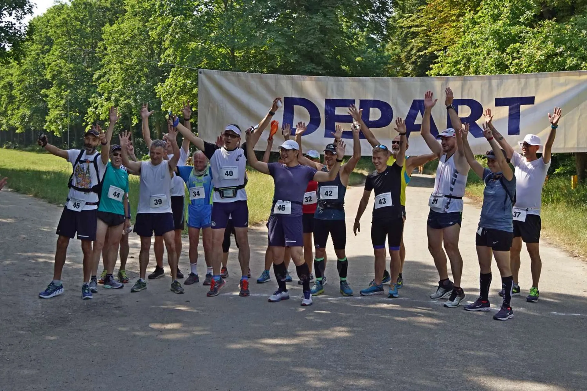 The image shows a group of people lined up at the starting line of a running