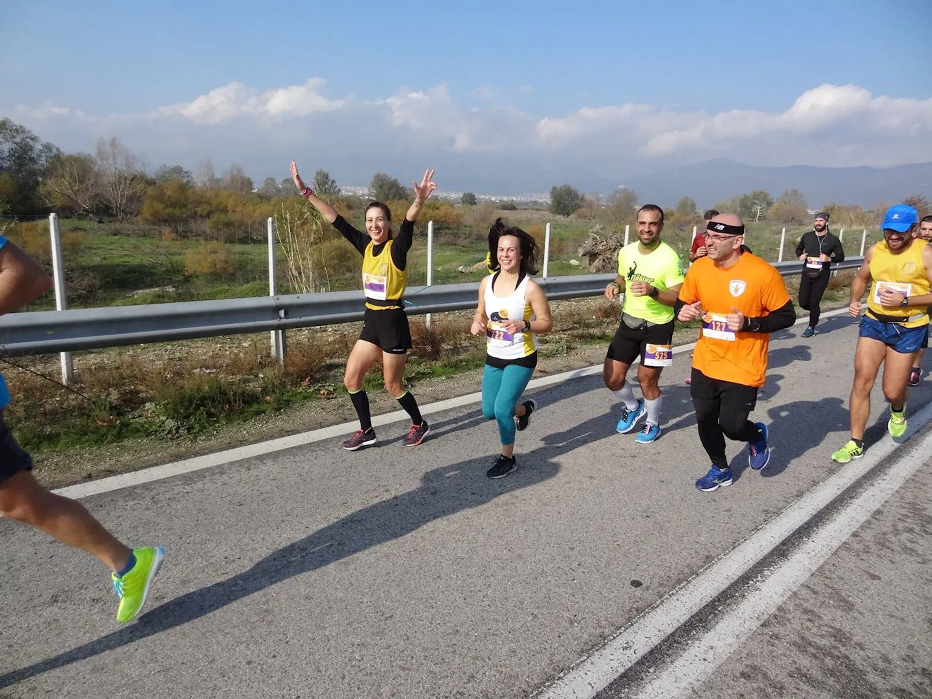 The image shows a group of runners participating in a road race. They appear to