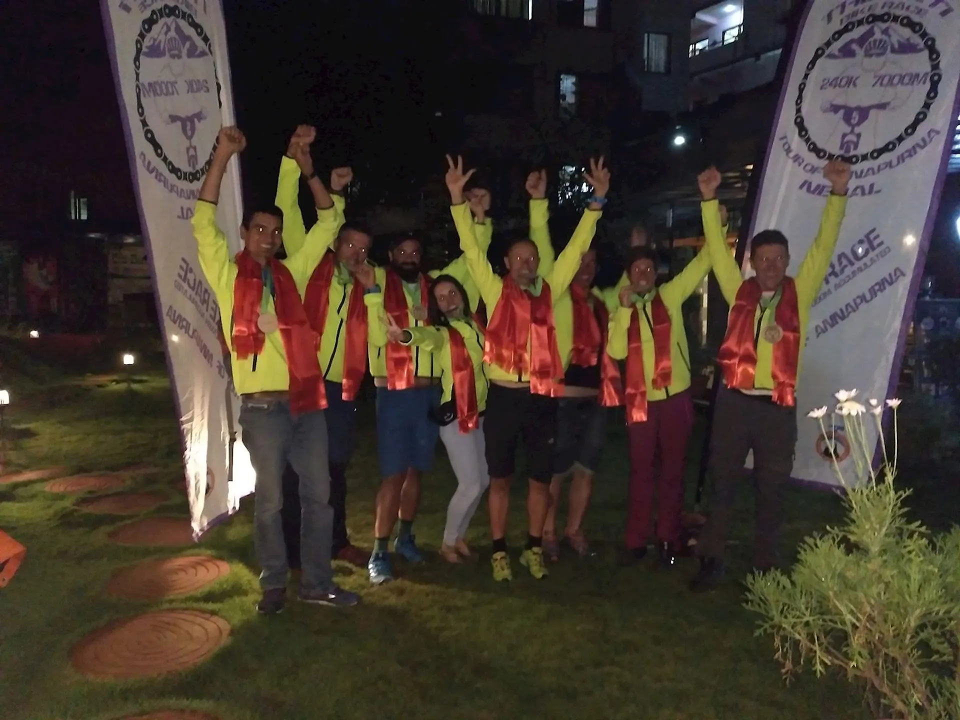 The image shows a group of people gathered together at night, celebrating or posing for