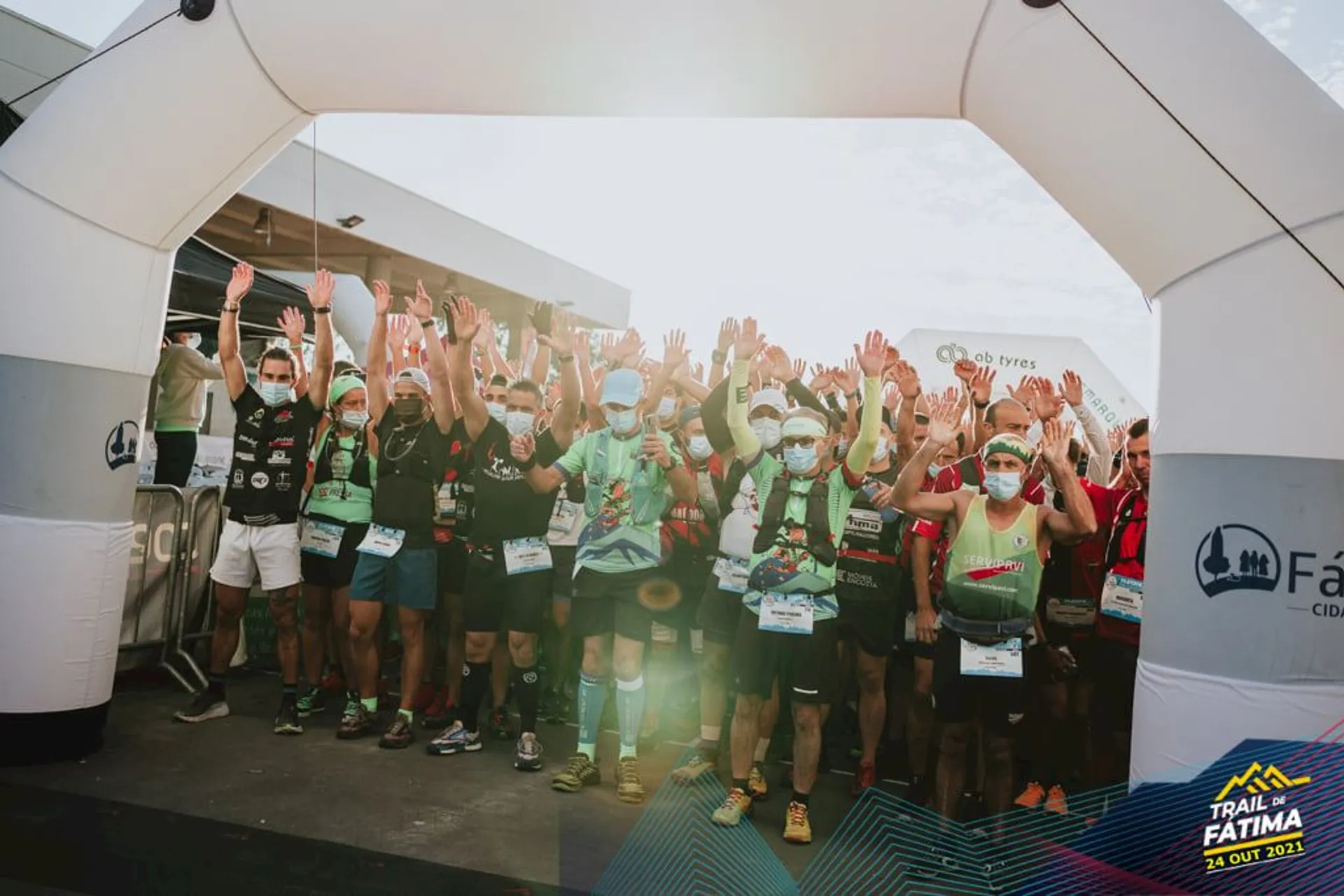 The image shows a group of individuals at a starting line of an outdoor event,