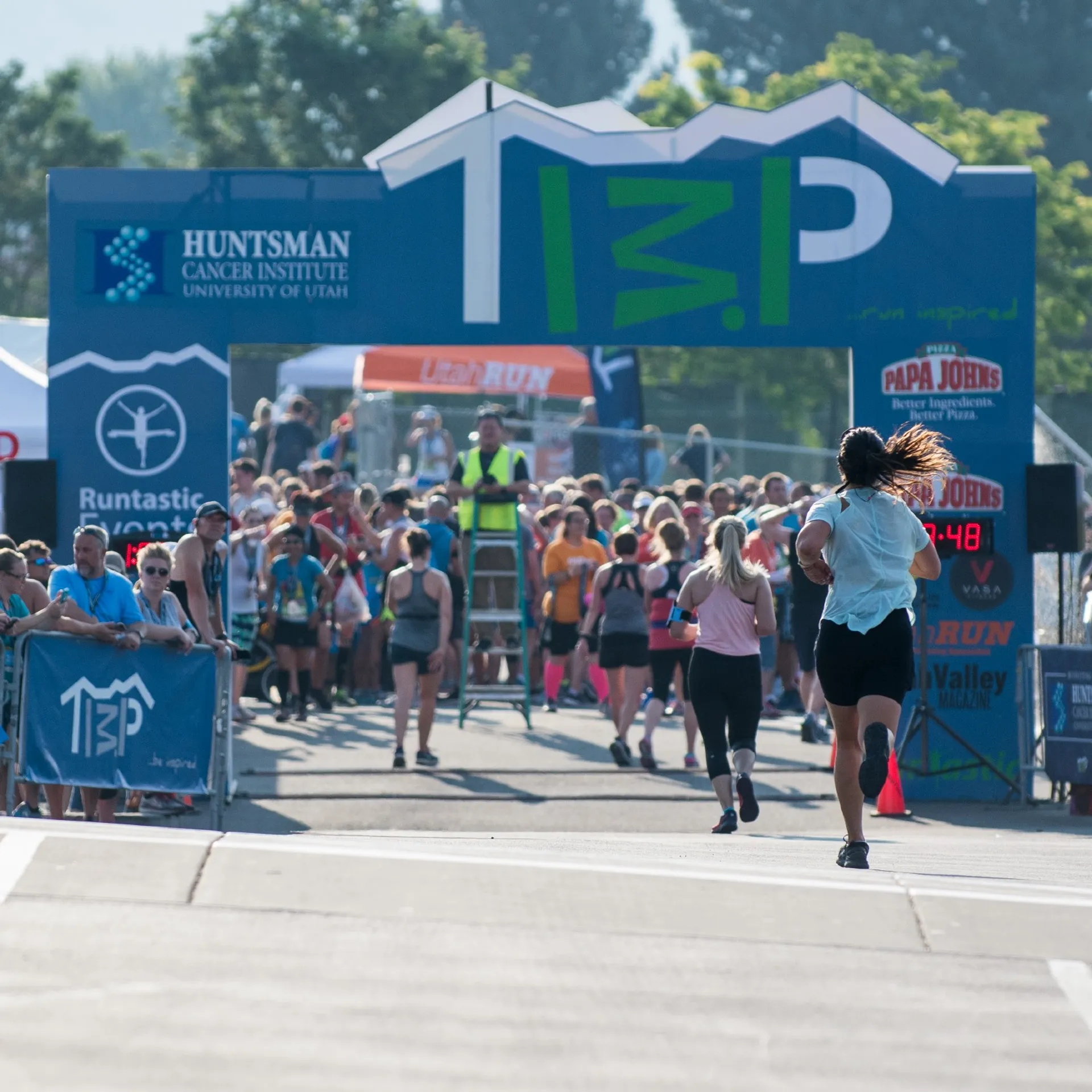 In this image, we see a runner crossing the finish line of a race.