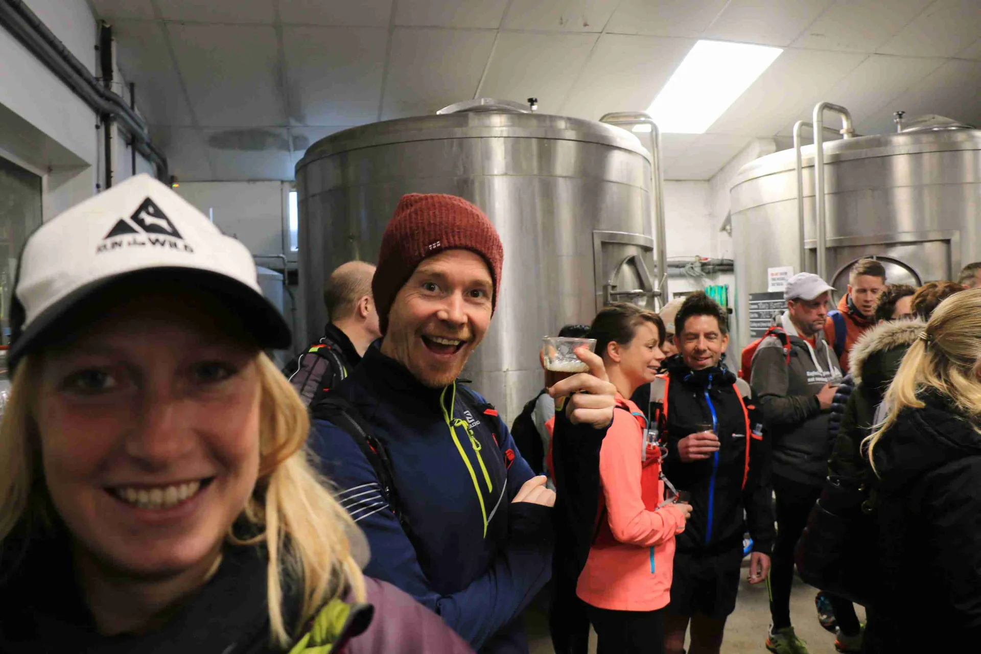 The image shows a group of people gathered in an industrial or commercial setting, which