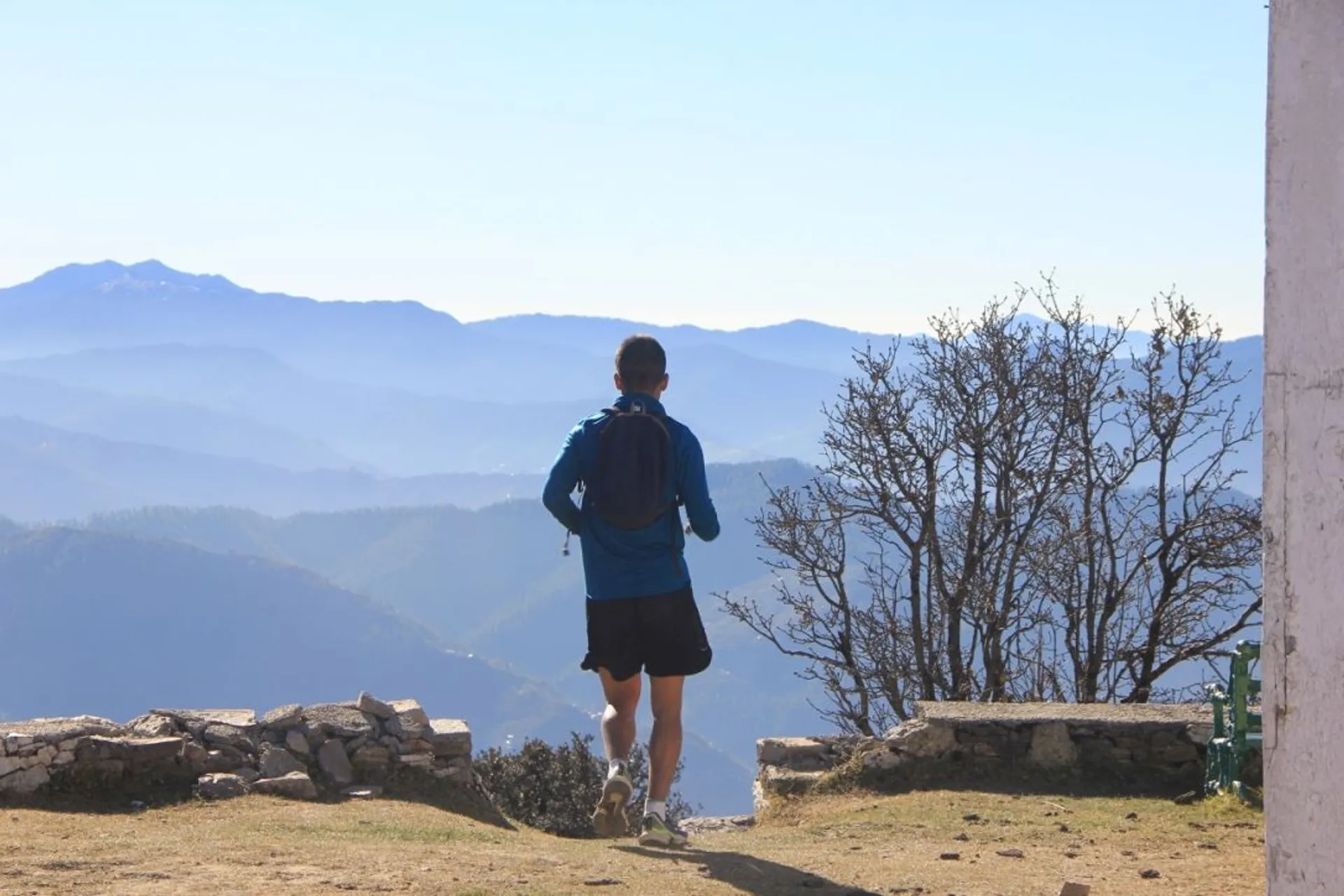 The image captures a person from behind as they seem to be walking toward a scenic