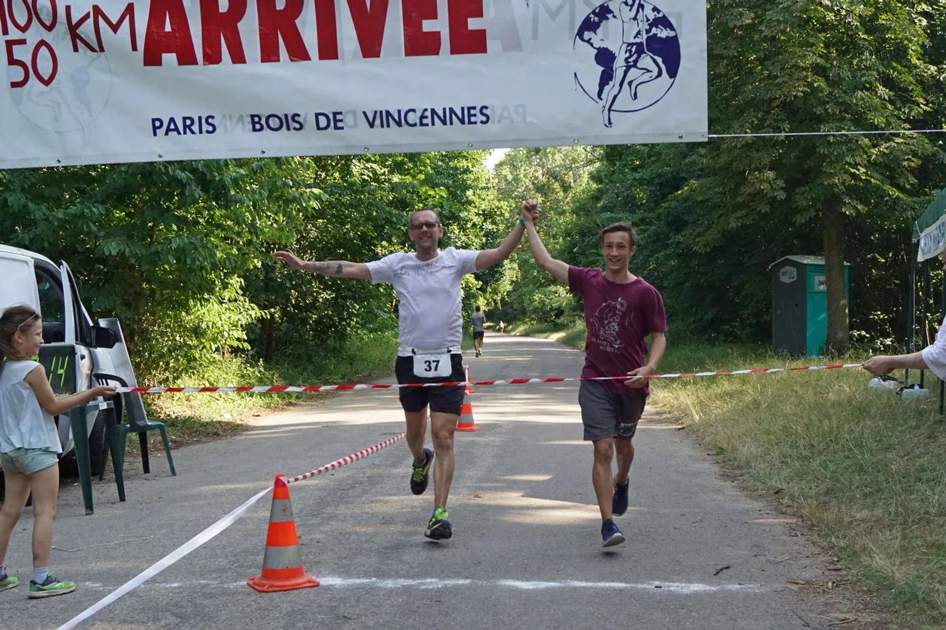 This is an image of two individuals crossing a finish line at a running event,
