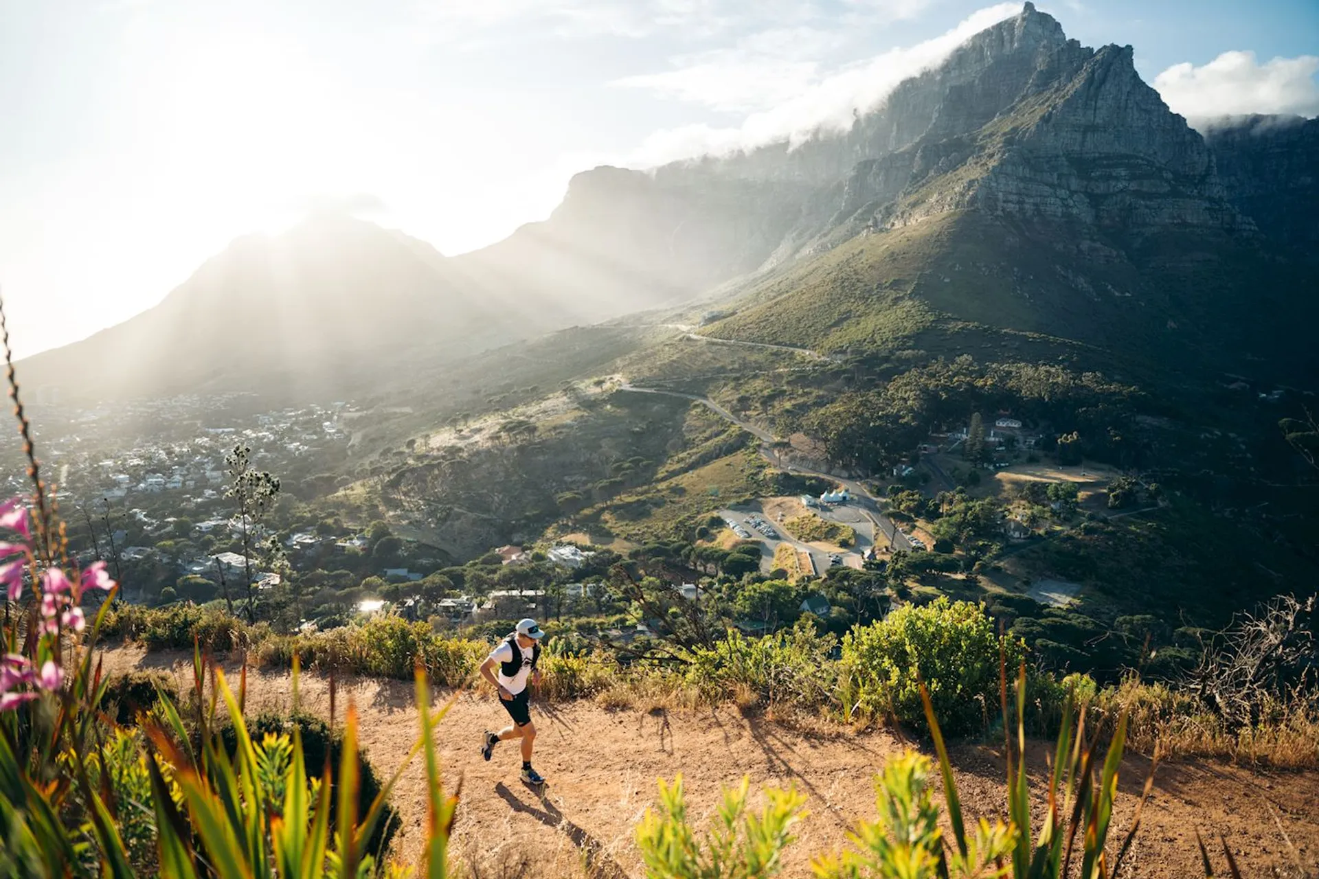 The image depicts a scenic landscape with a person running on a trail. The backdrop