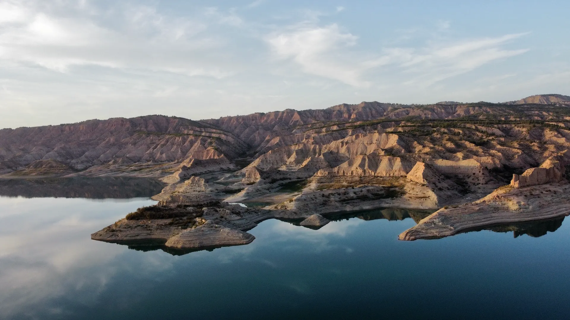 This image shows a serene landscape featuring a large body of water that reflects the sky