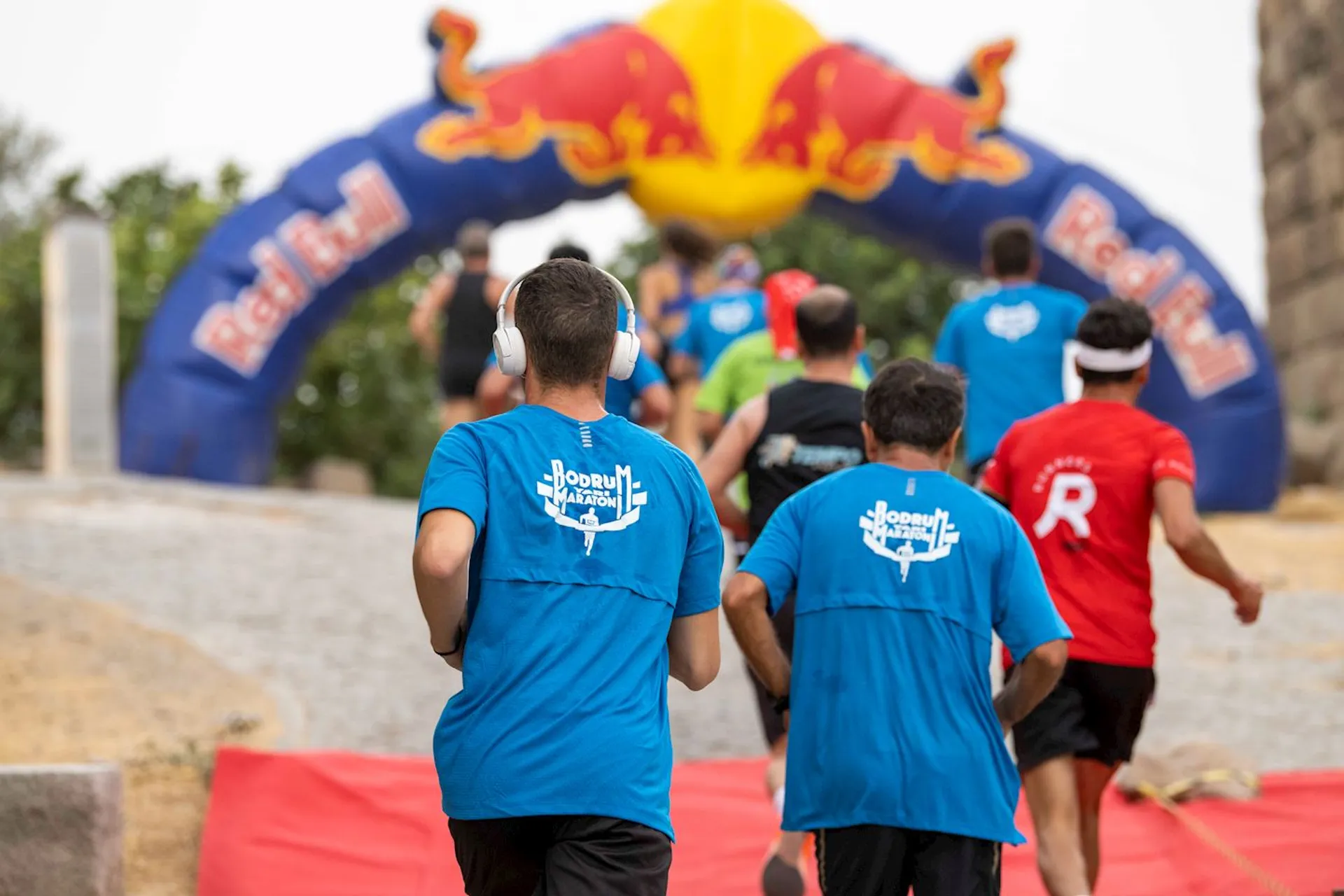 The image shows a group of people participating in a running event. They are running