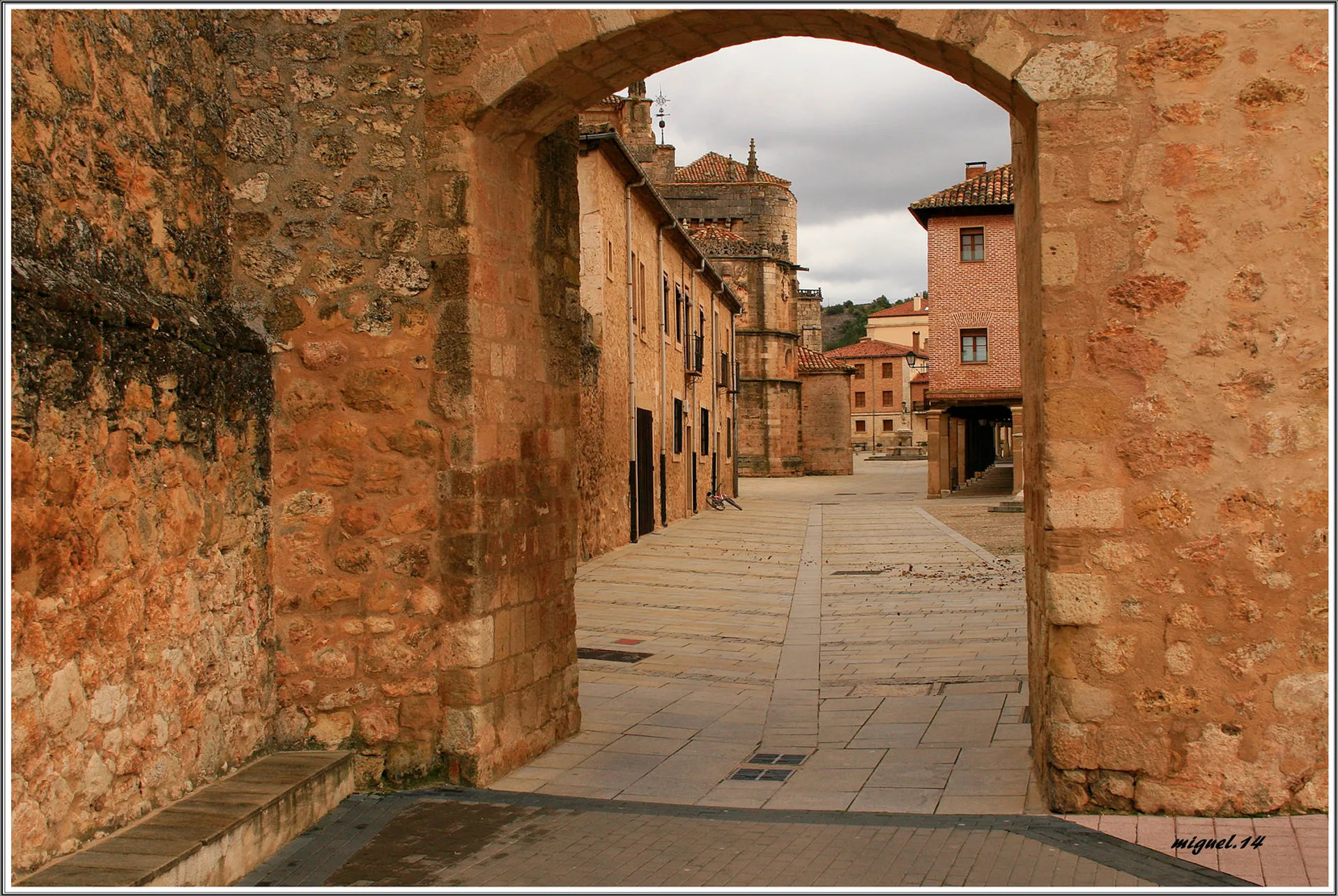 The image depicts a picturesque scene of an old street. In the foreground, there