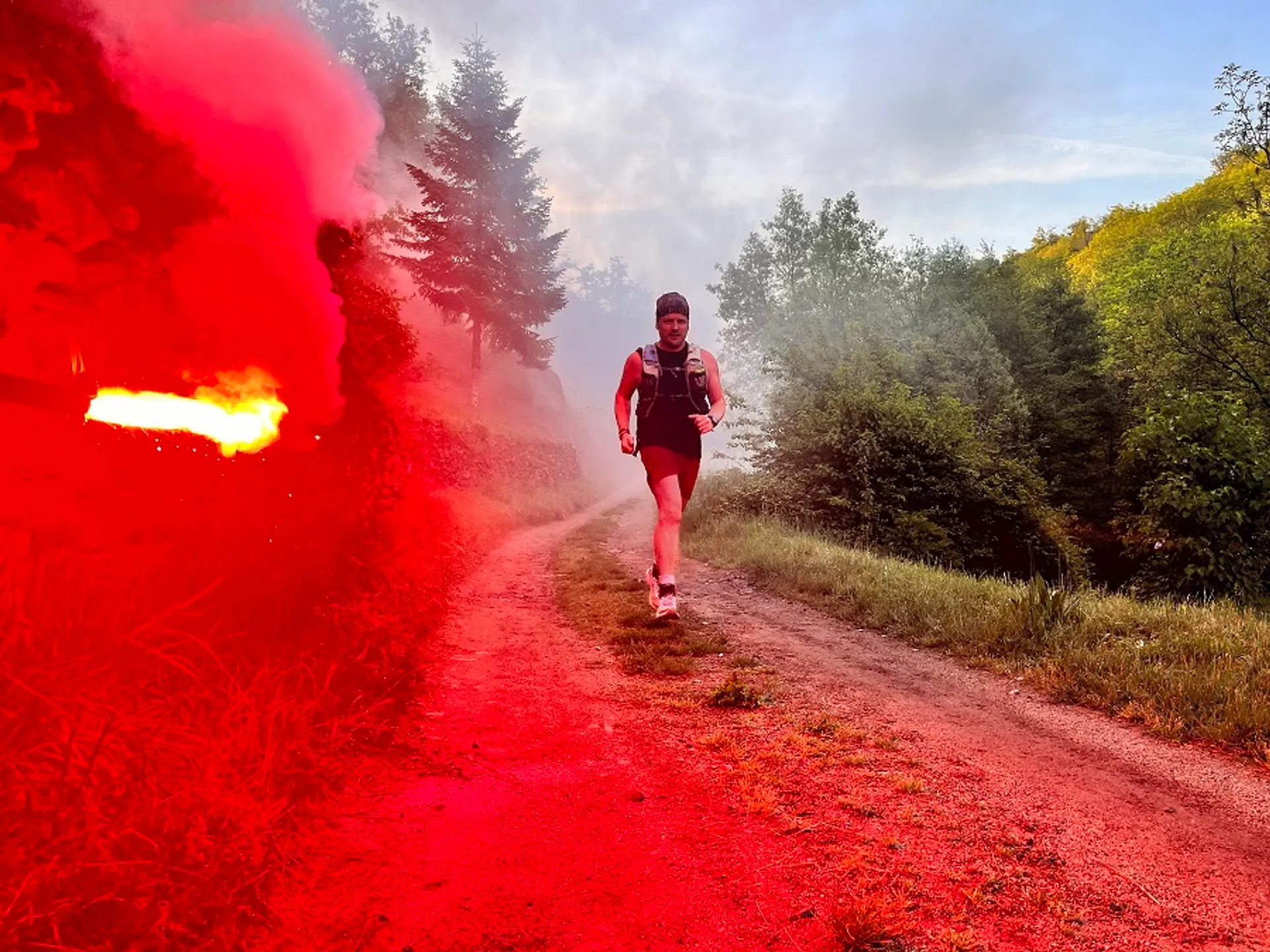 The image shows a person running on a dirt trail. To the left of the