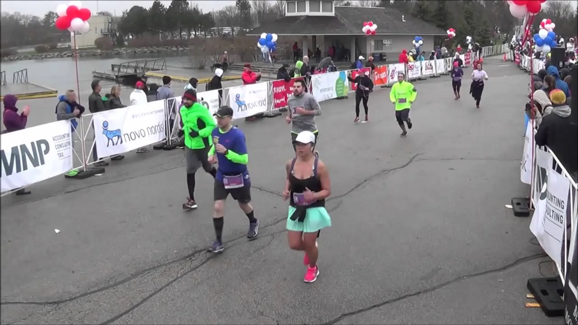 The image shows a group of runners participating in a race. They are crossing what