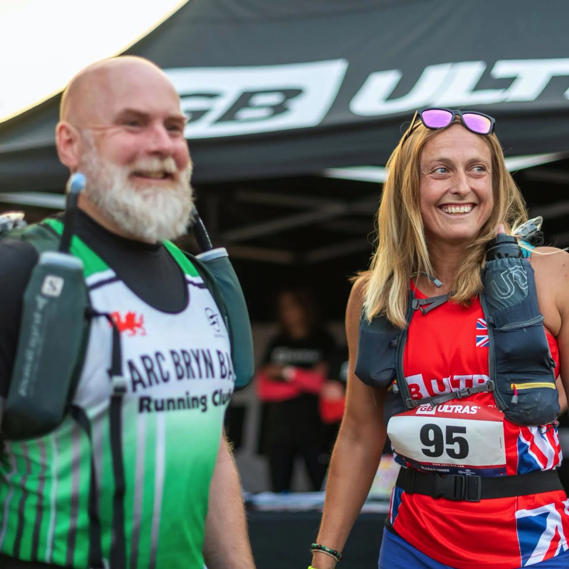 The image depicts two individuals appearing to be at an athletic or outdoor event, possibly