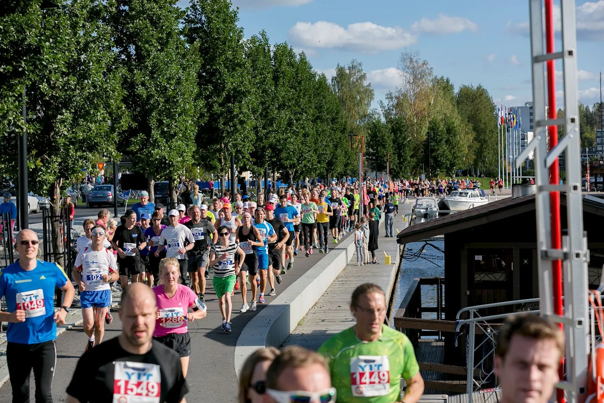 The image shows a group of people participating in a running event. Runners are