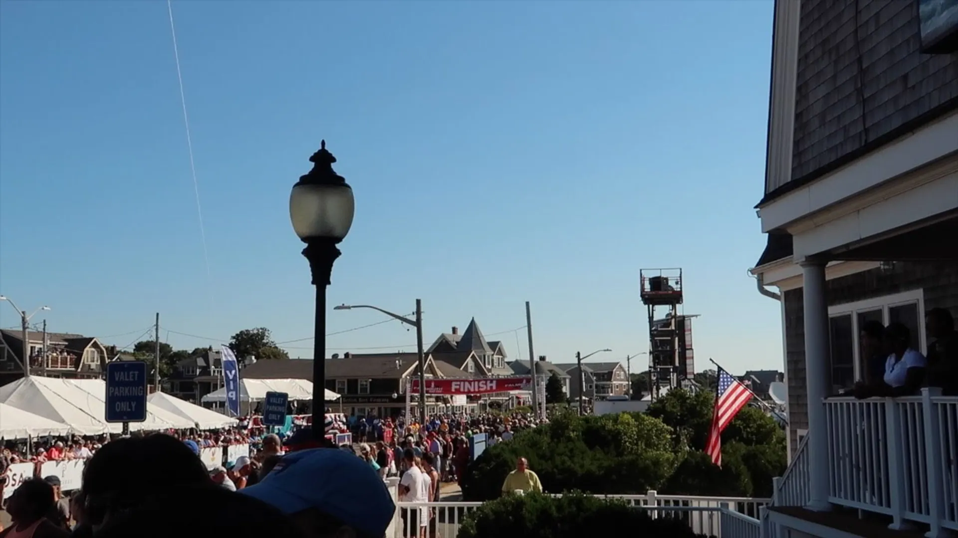 In the image, we see an outdoor event with a large gathering of people.