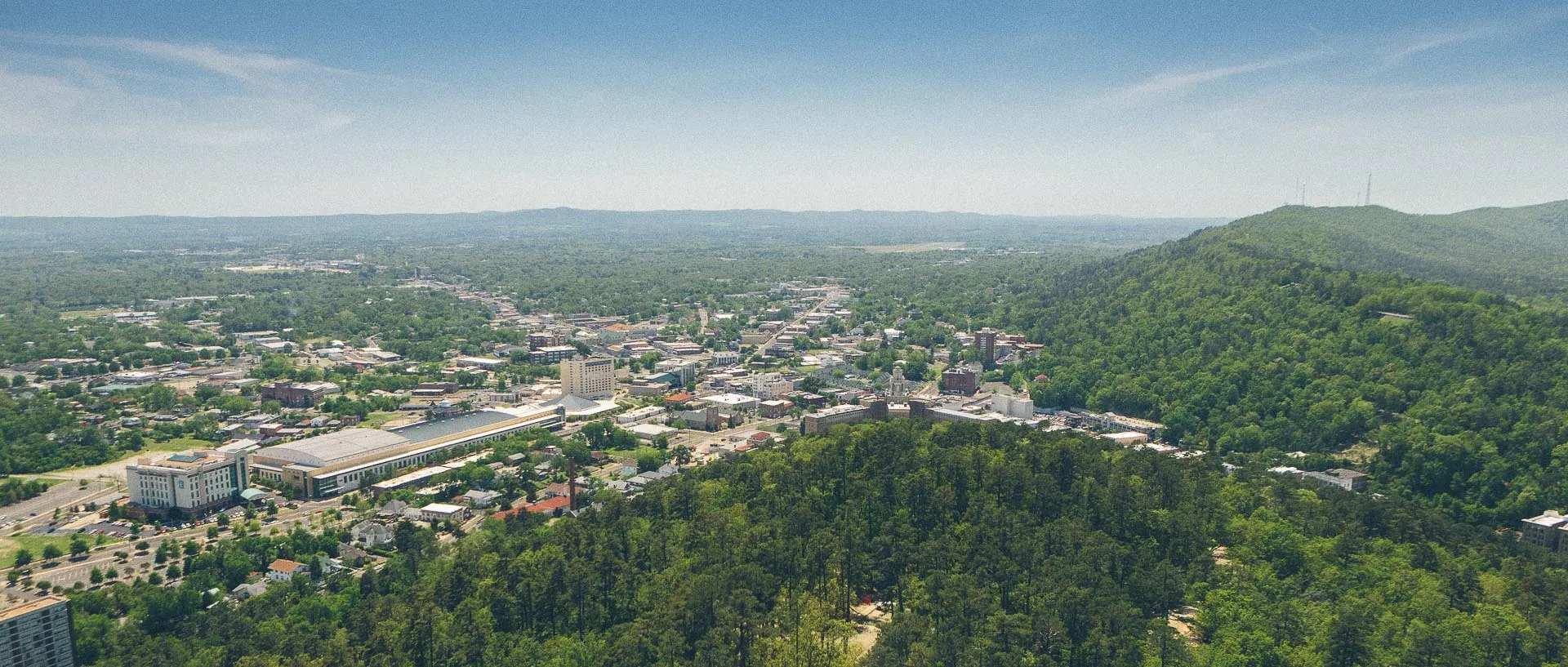 The image shows an aerial view of a small to medium-sized city nestled in a