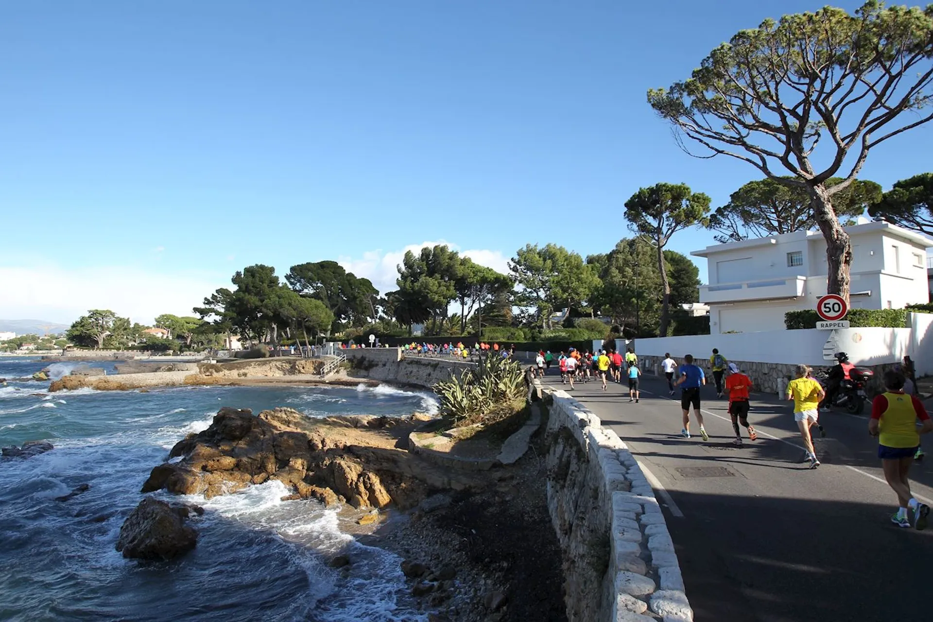 This image depicts a coastal scene where a group of people appears to be participating in